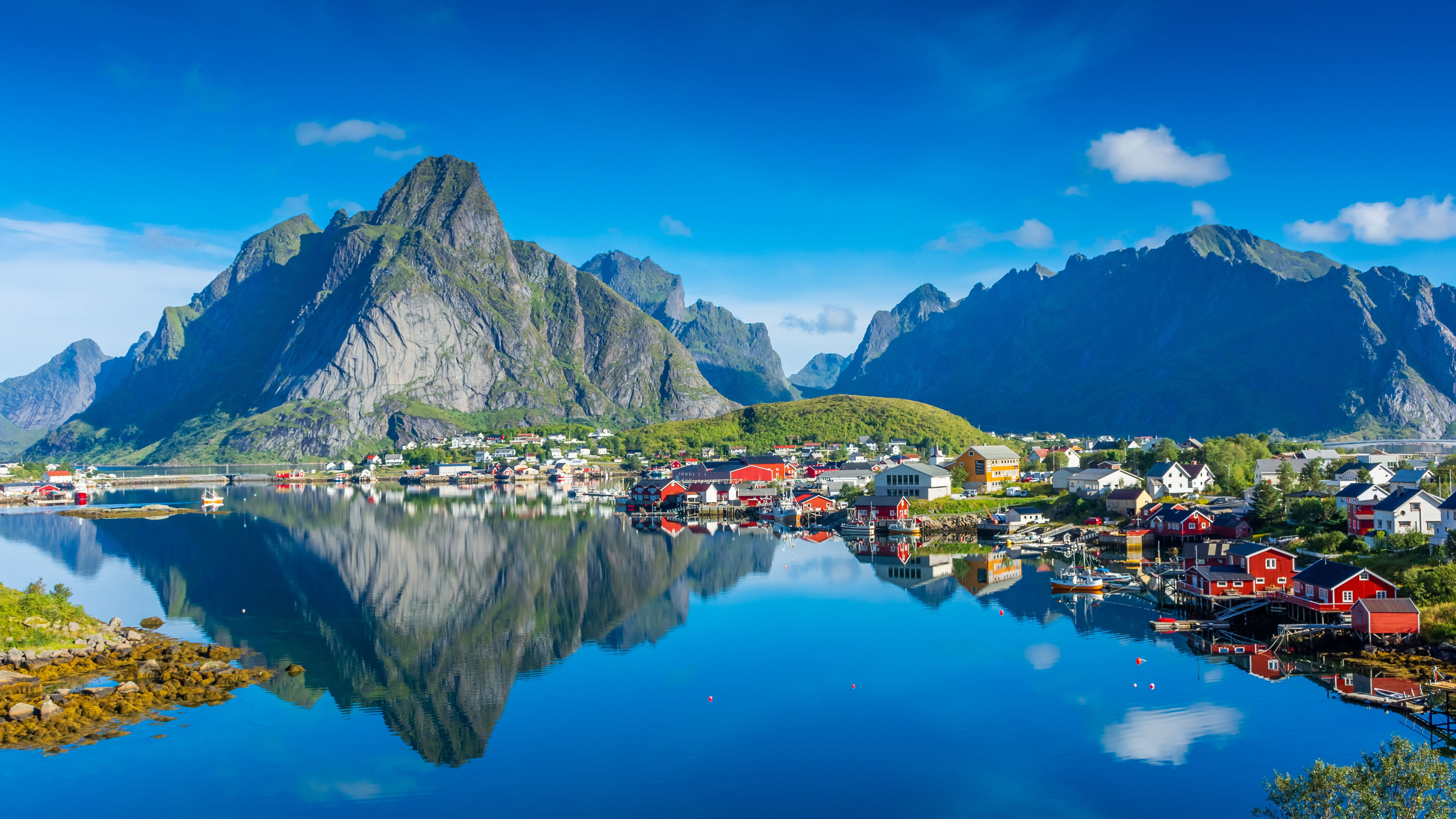 Bunte Häuser am Wasser vor majestätischen Bergen, Lofoten.