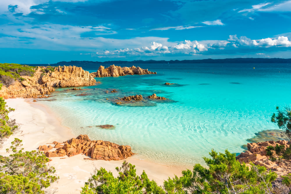 Türkisblaues Meer, Sandstrand und Felsen auf Sardinien, Italien.