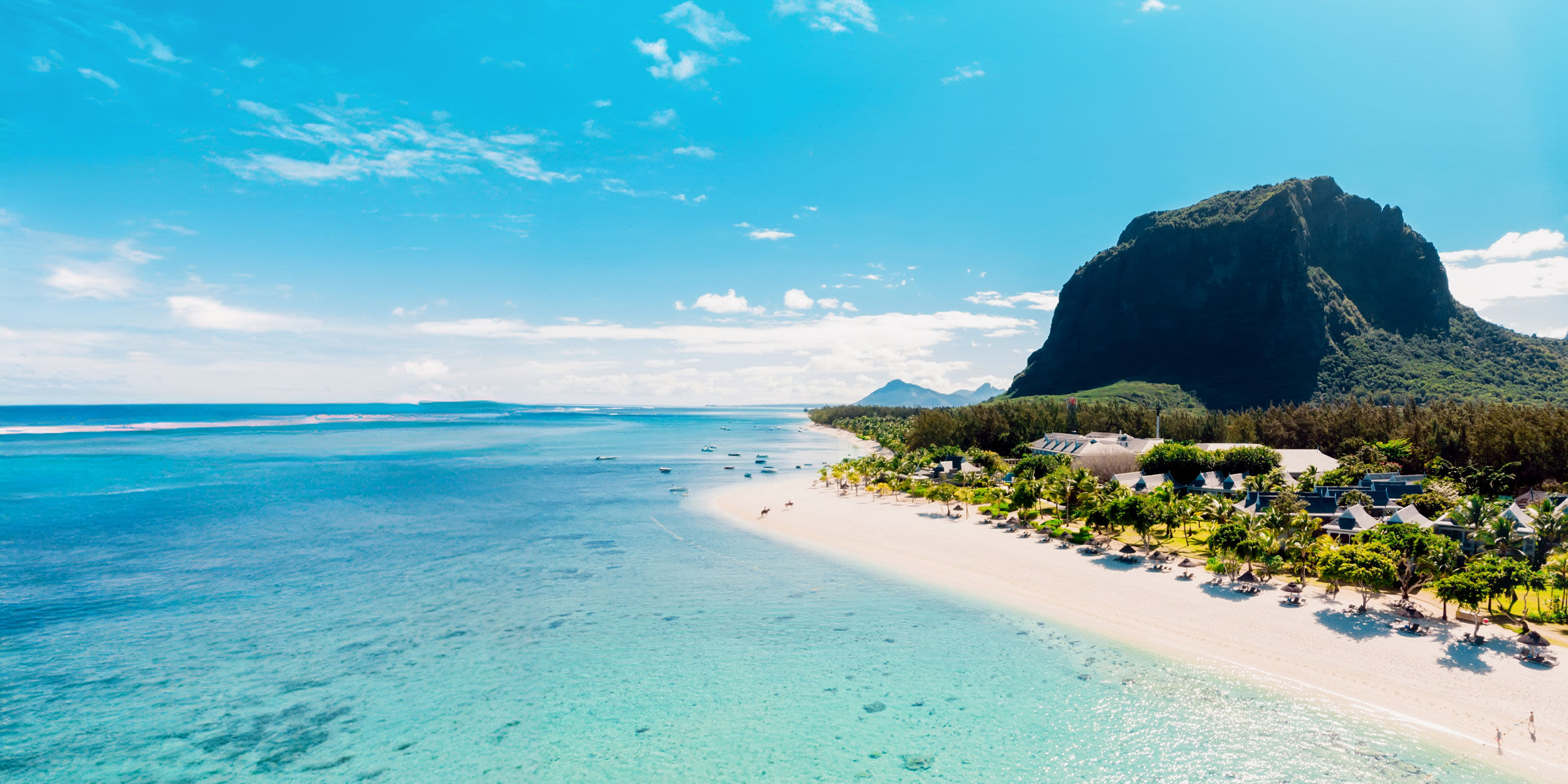 Strand von Le Morne, Mauritius, mit türkisfarbenem Wasser und Bergkulisse.