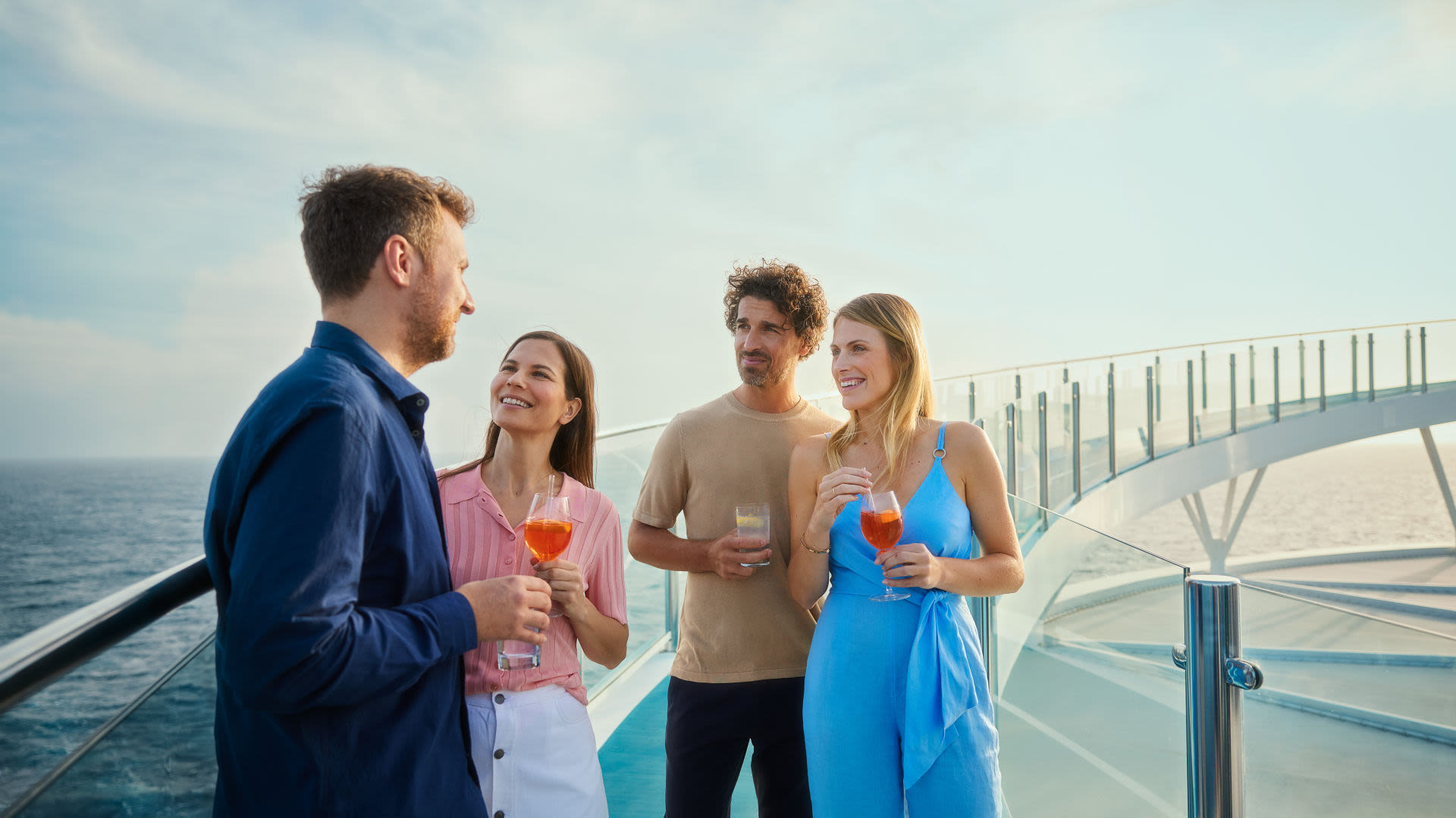 Vier Personen genießen Getränke auf einem Kreuzfahrtschiff der Mein Schiff® Flotte.