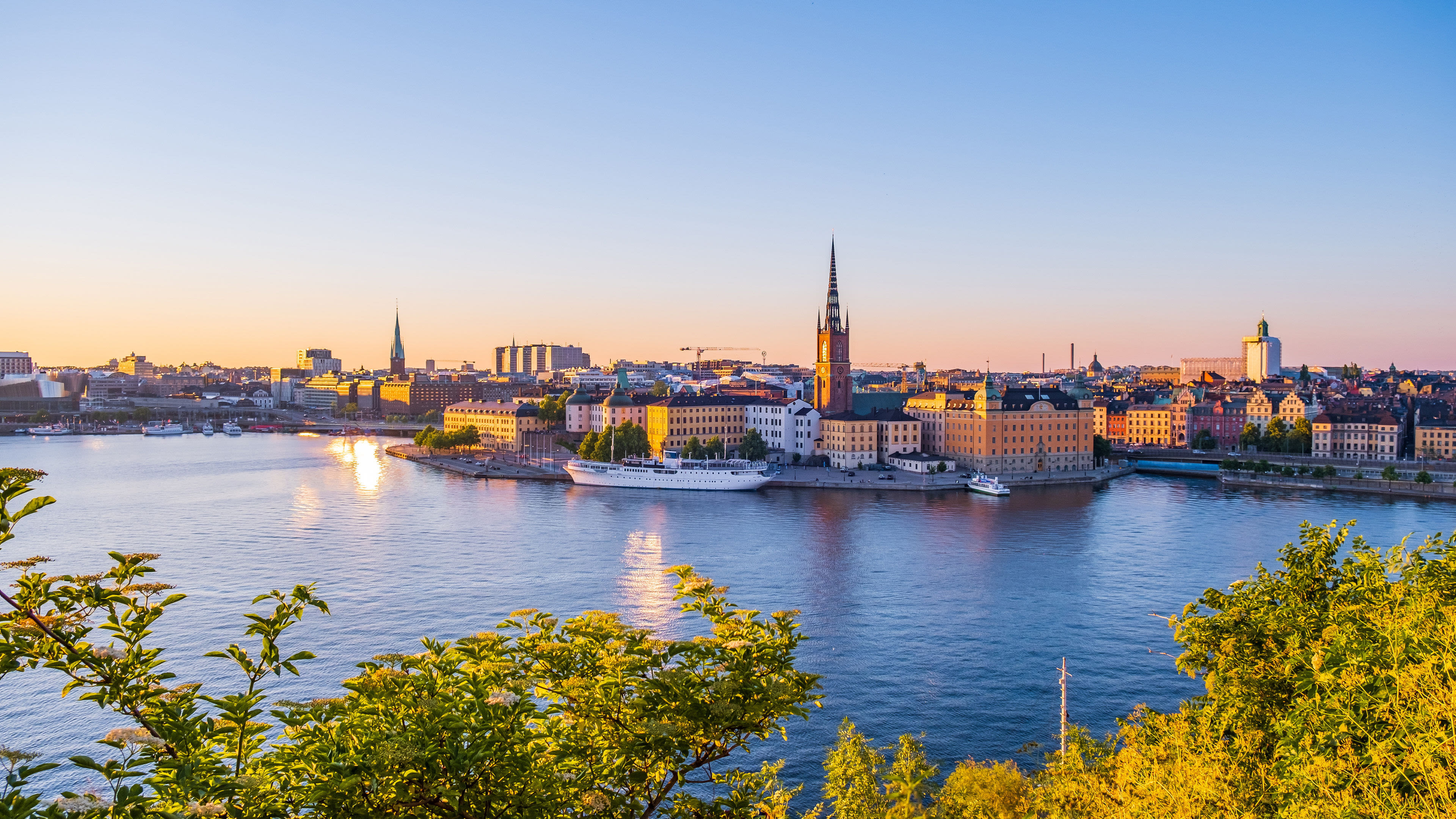 Stockholm bei Sonnenuntergang, Wasser, Gebäude, Kirche, blauer Himmel. Stockholm bei Sonnenuntergang, Wasser, Gebäude, Kirche, blauer Himmel.