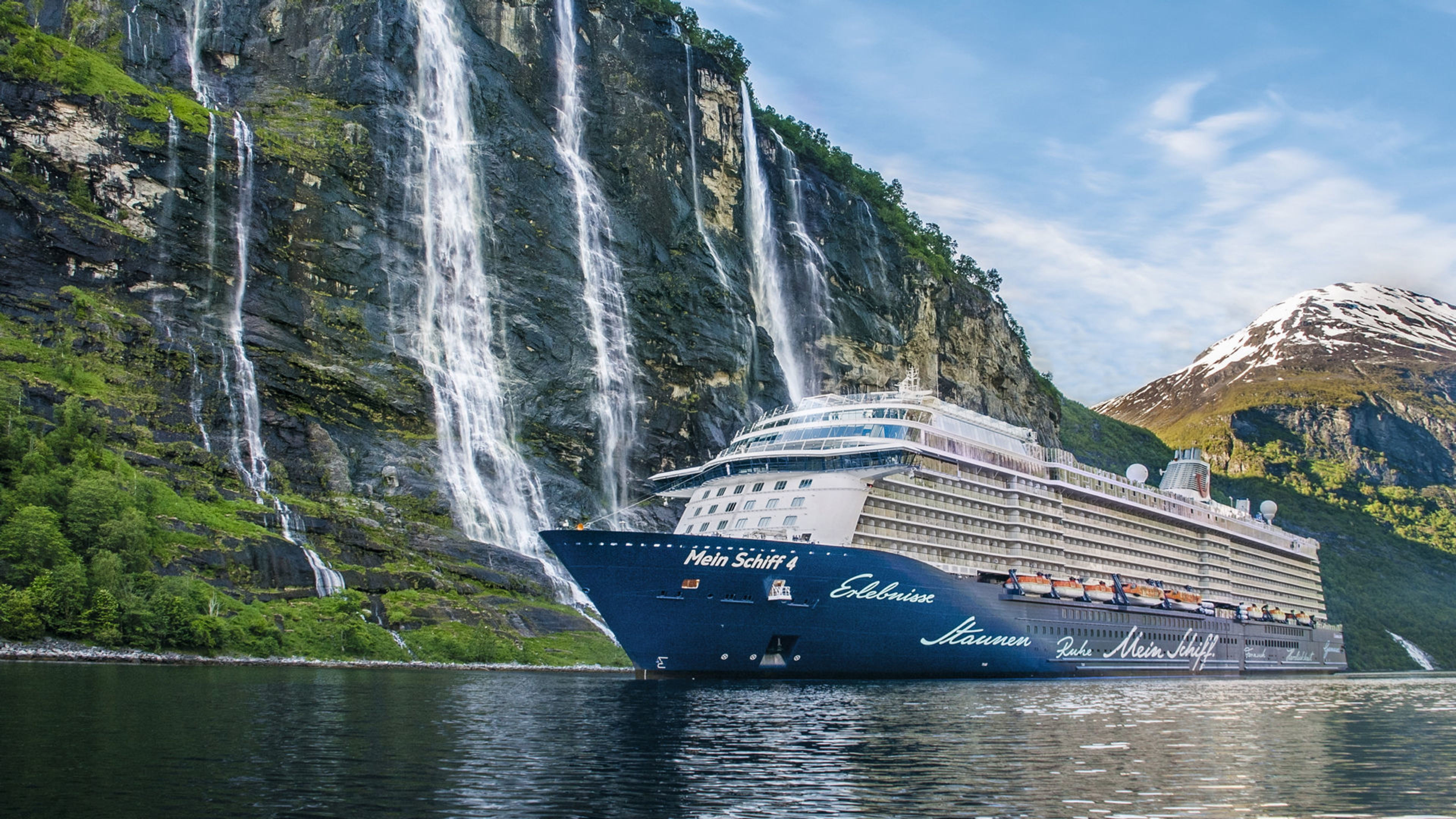 Kreuzfahrtschiff der Mein Schiff® Flotte vor Wasserfällen im Geirangerfjord, Norwegen. Kreuzfahrtschiff der Mein Schiff® Flotte vor Wasserfällen im Geirangerfjord, Norwegen.