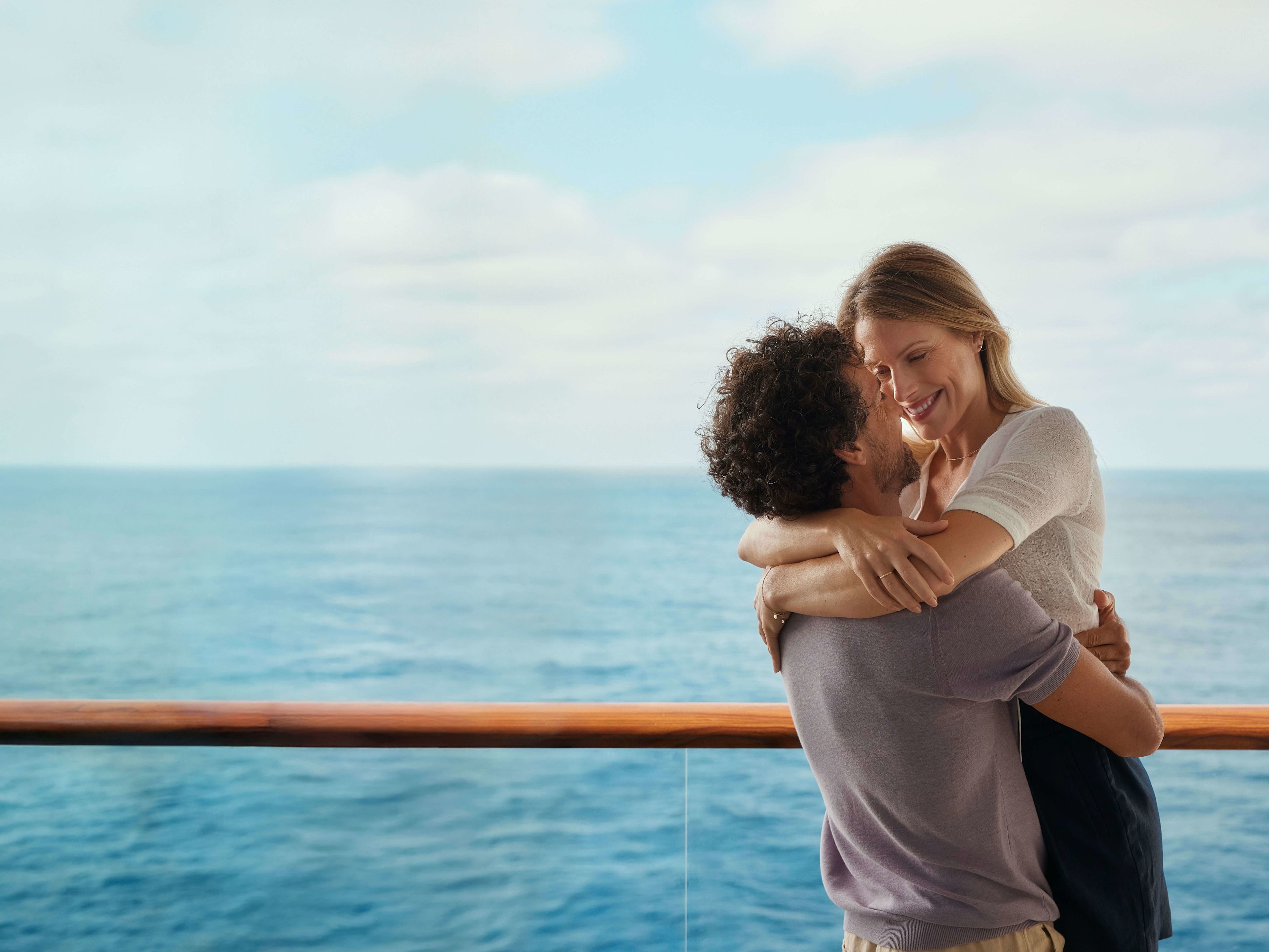 Paar umarmt sich auf Kreuzfahrtschiff, Meer im Hintergrund. Paar umarmt sich auf Kreuzfahrtschiff, Meer im Hintergrund.
