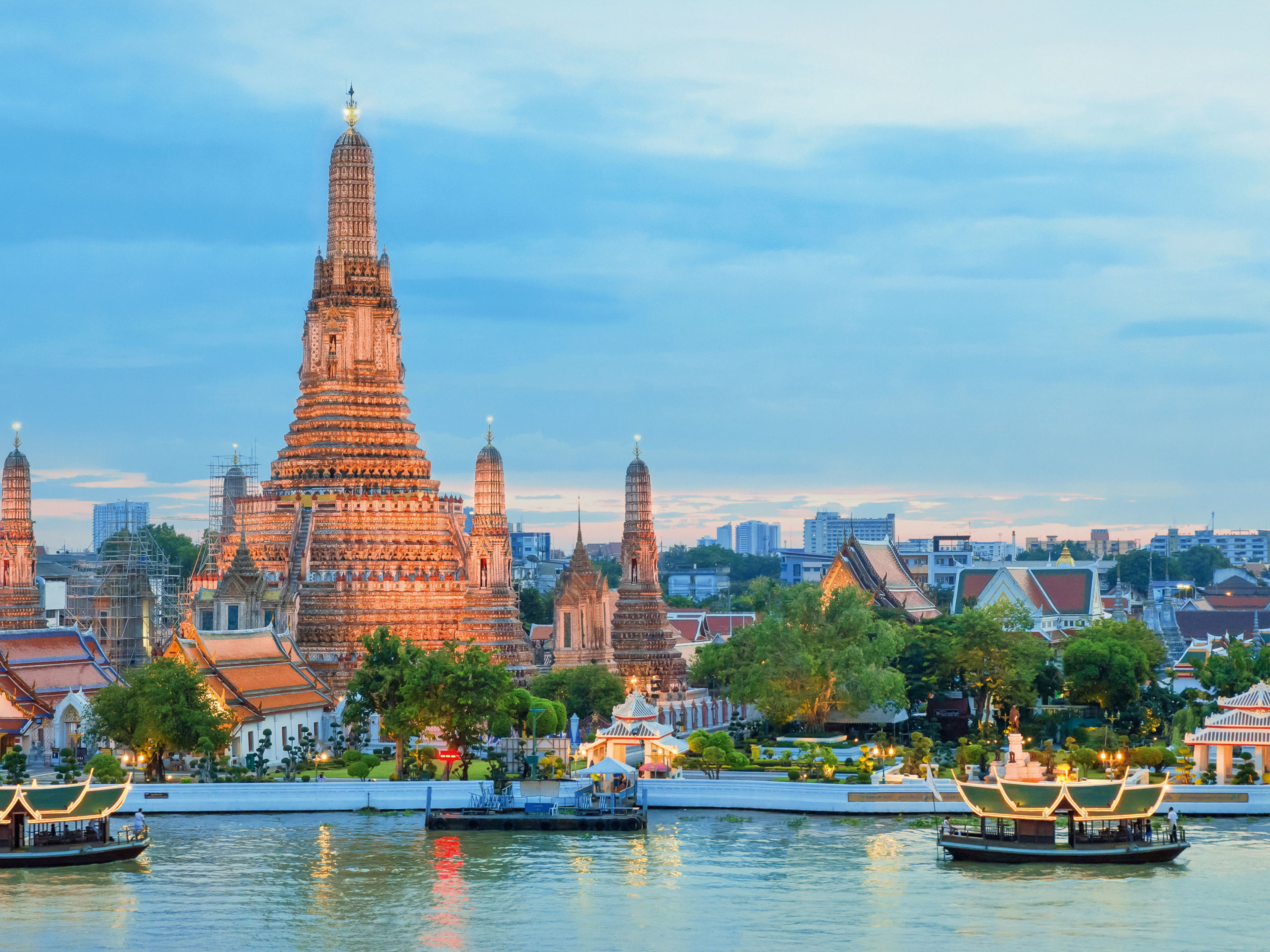 Wat Arun Tempel bei Sonnenuntergang, Bangkok, mit Booten auf dem Fluss. Wat Arun Tempel bei Sonnenuntergang, Bangkok, mit Booten auf dem Fluss.