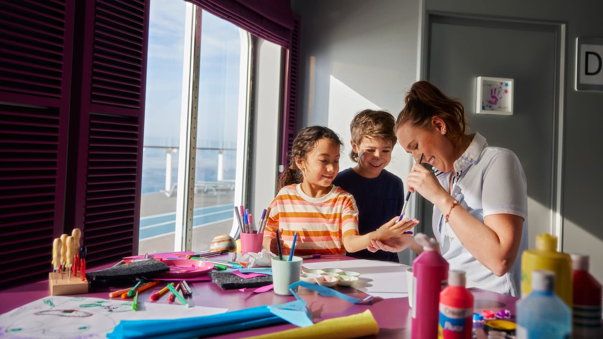 Kinder basteln mit Betreuerin auf Kreuzfahrtschiff der Mein Schiff® Flotte.