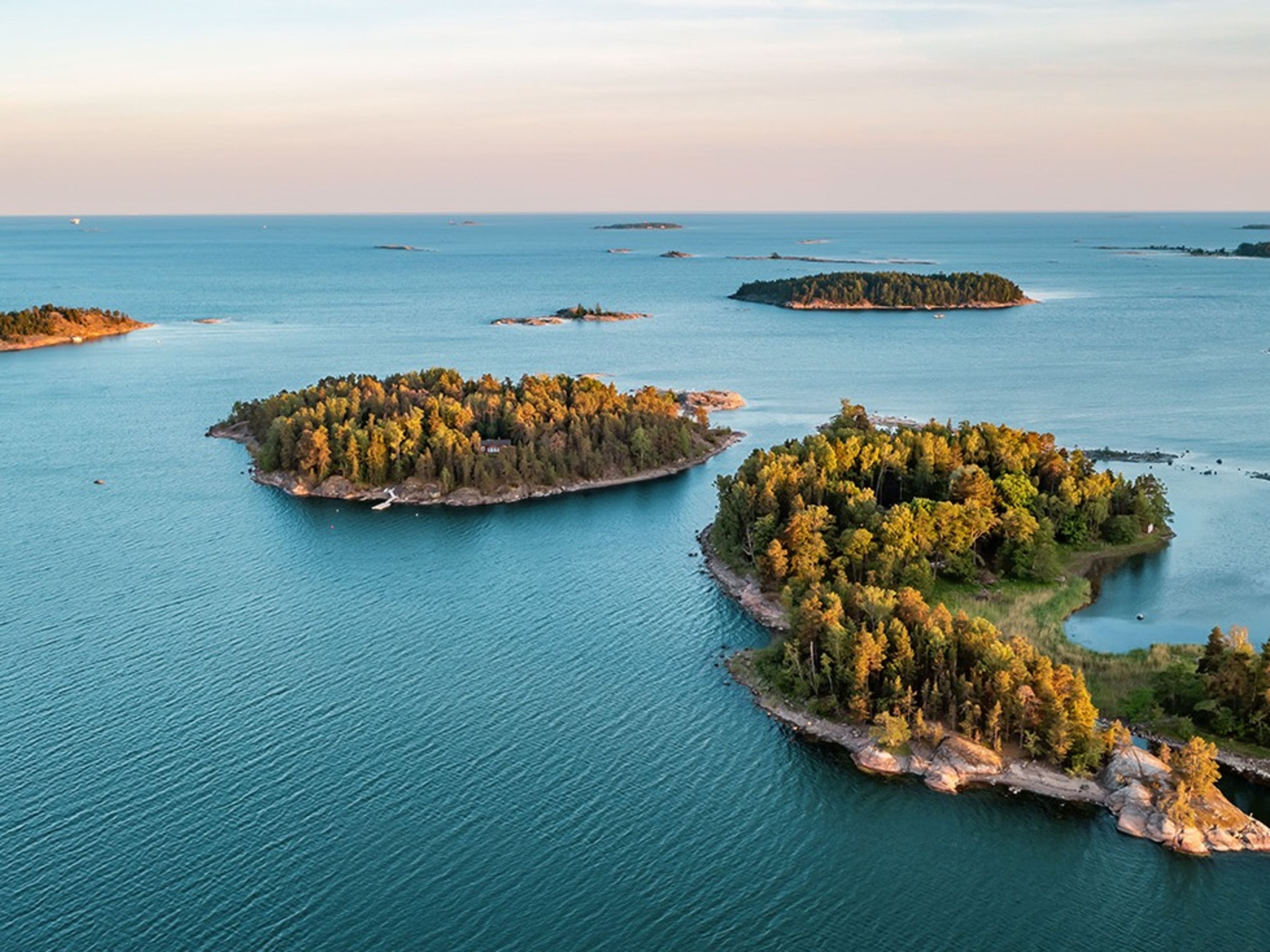 Inseln im Archipel, umgeben von blauem Meer, Sonnenuntergang. Inseln im Archipel, umgeben von blauem Meer, Sonnenuntergang.