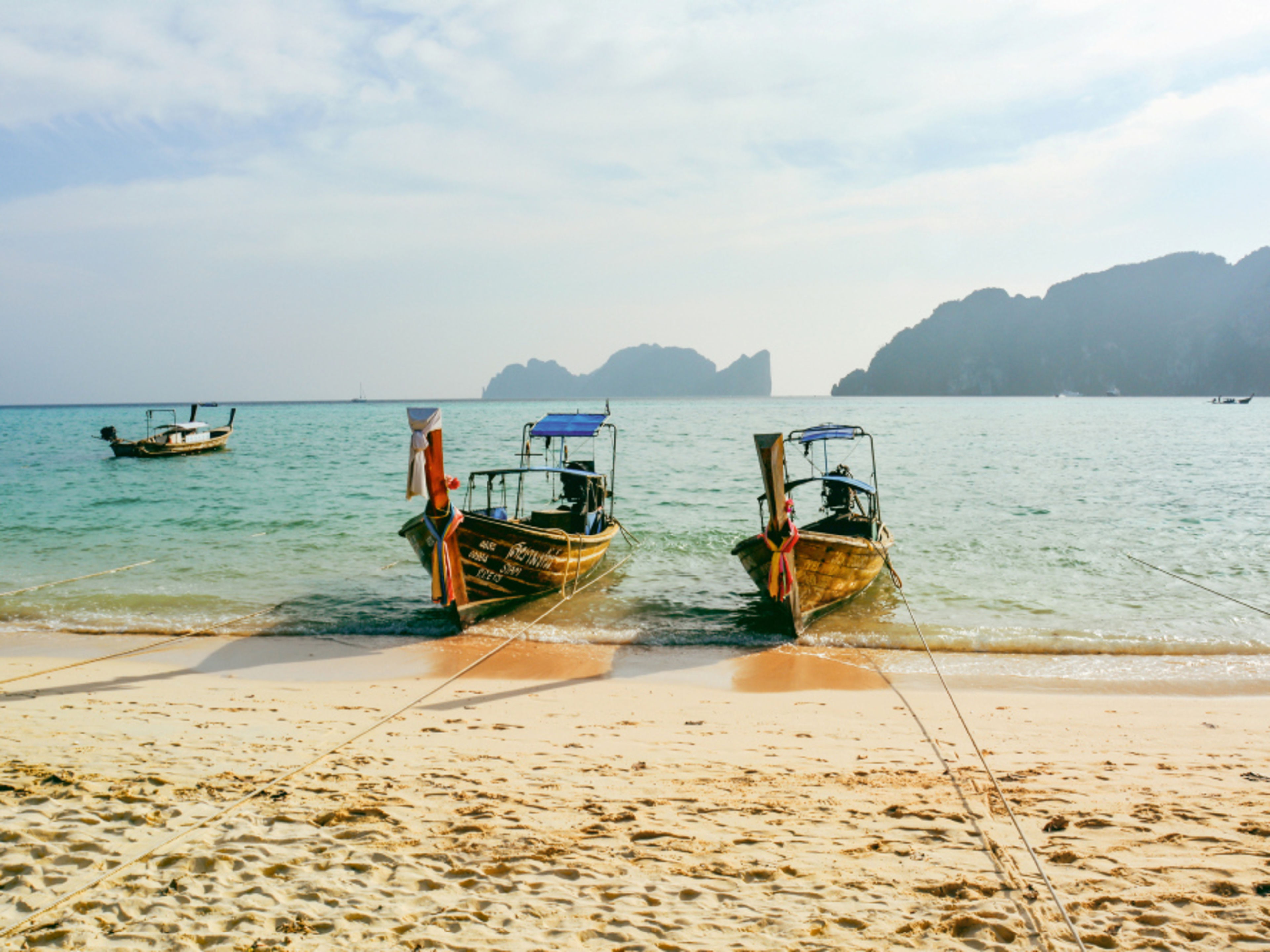 Zwei Longtail-Boote am Strand von Ko Phi Phi, Thailand. Zwei Longtail-Boote am Strand von Ko Phi Phi, Thailand.