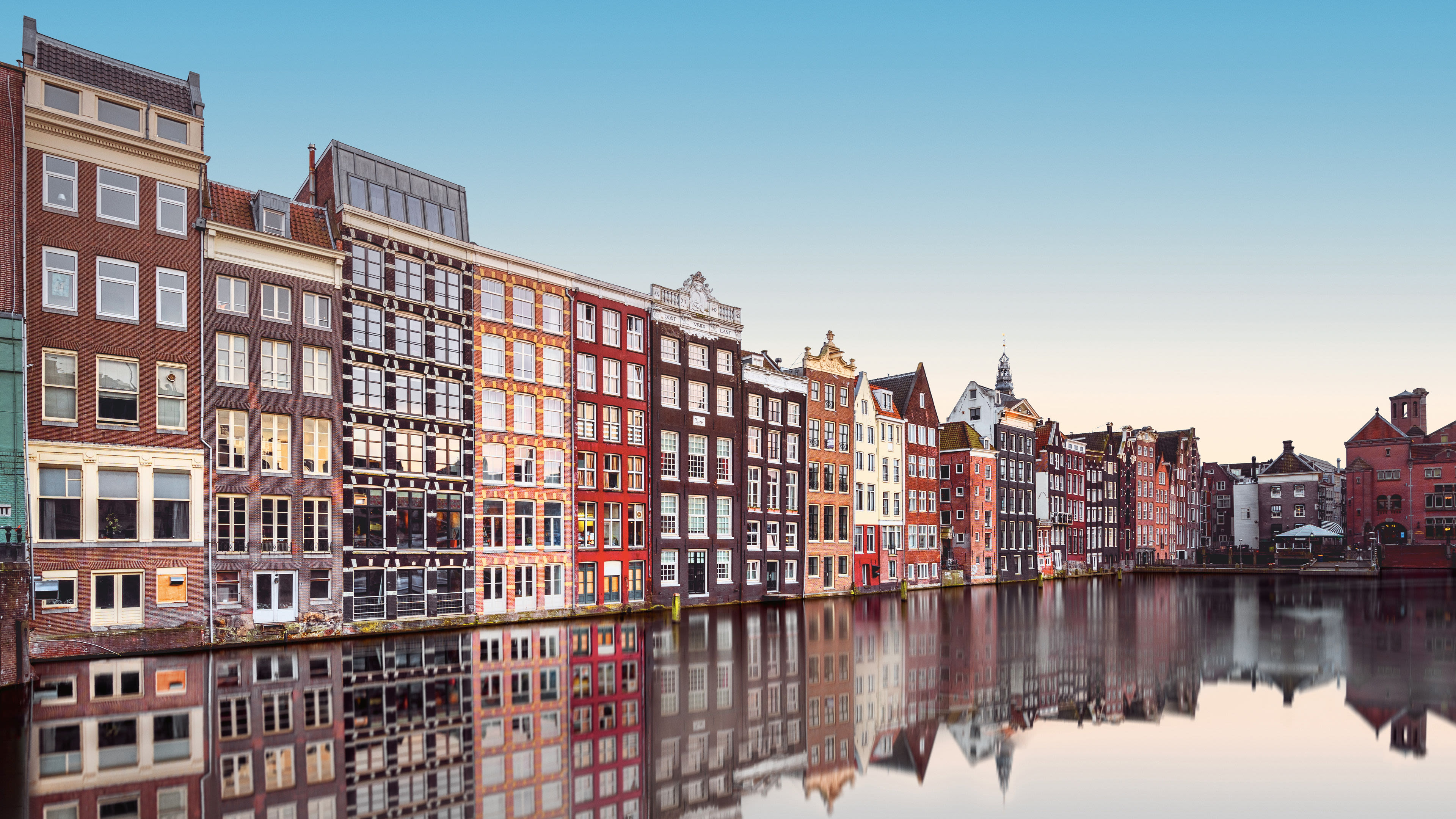 Bunte Häuser am Kanal in Amsterdam, spiegelnd im Wasser. Bunte Häuser am Kanal in Amsterdam, spiegelnd im Wasser.