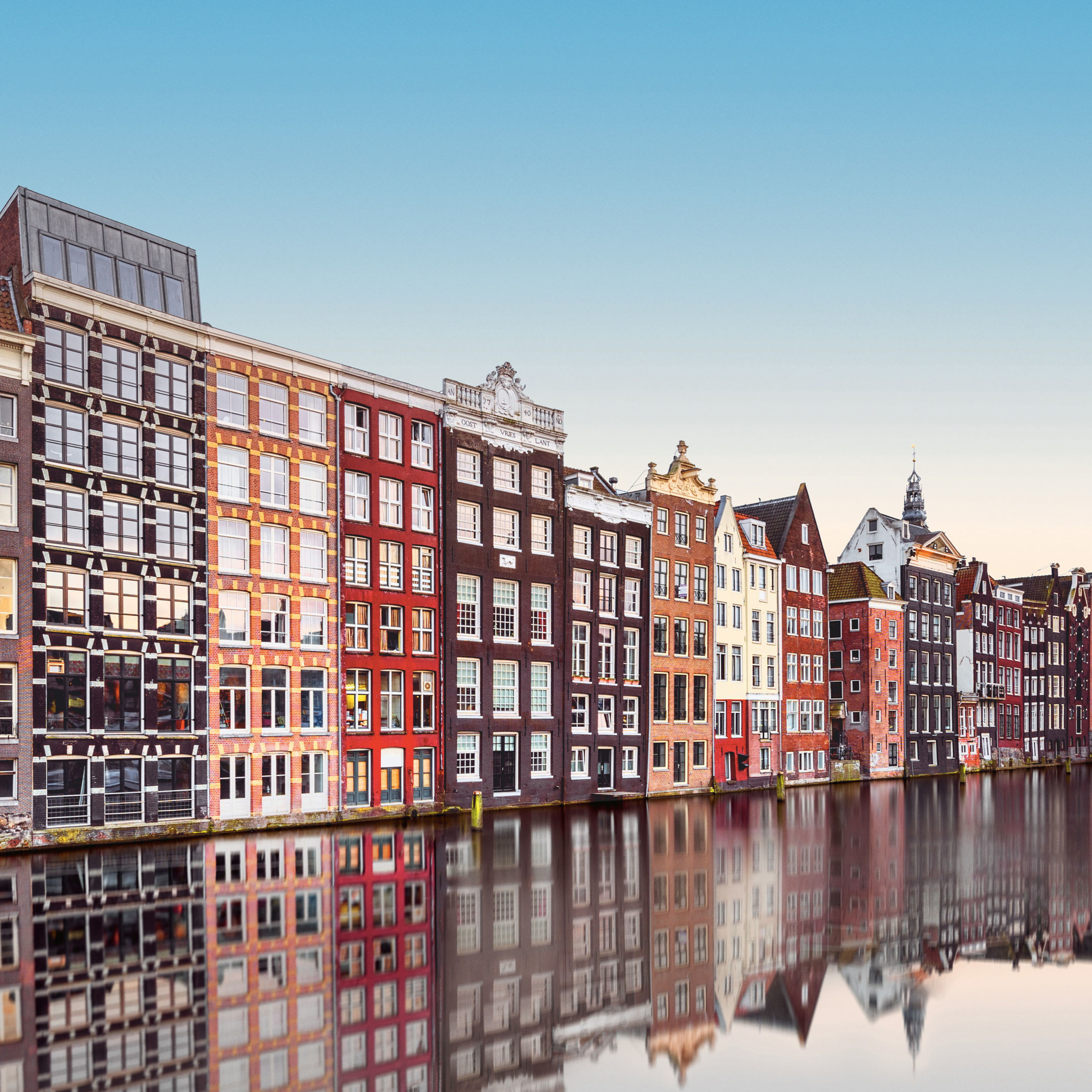Bunte Häuser am Kanal in Amsterdam, spiegelnd im Wasser. Bunte Häuser am Kanal in Amsterdam, spiegelnd im Wasser.