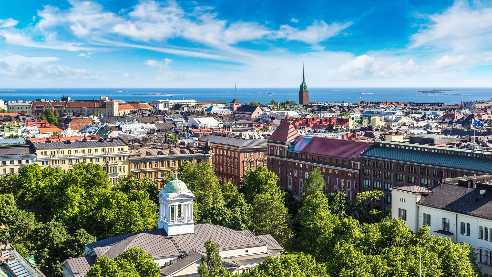 Stadtansicht von Helsinki mit blauem Himmel und Meer im Hintergrund.