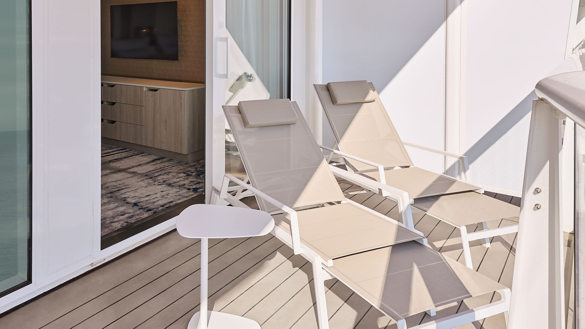 Zwei Liegestühle auf Balkon eines Kreuzfahrtschiffs der Mein Schiff® Flotte.