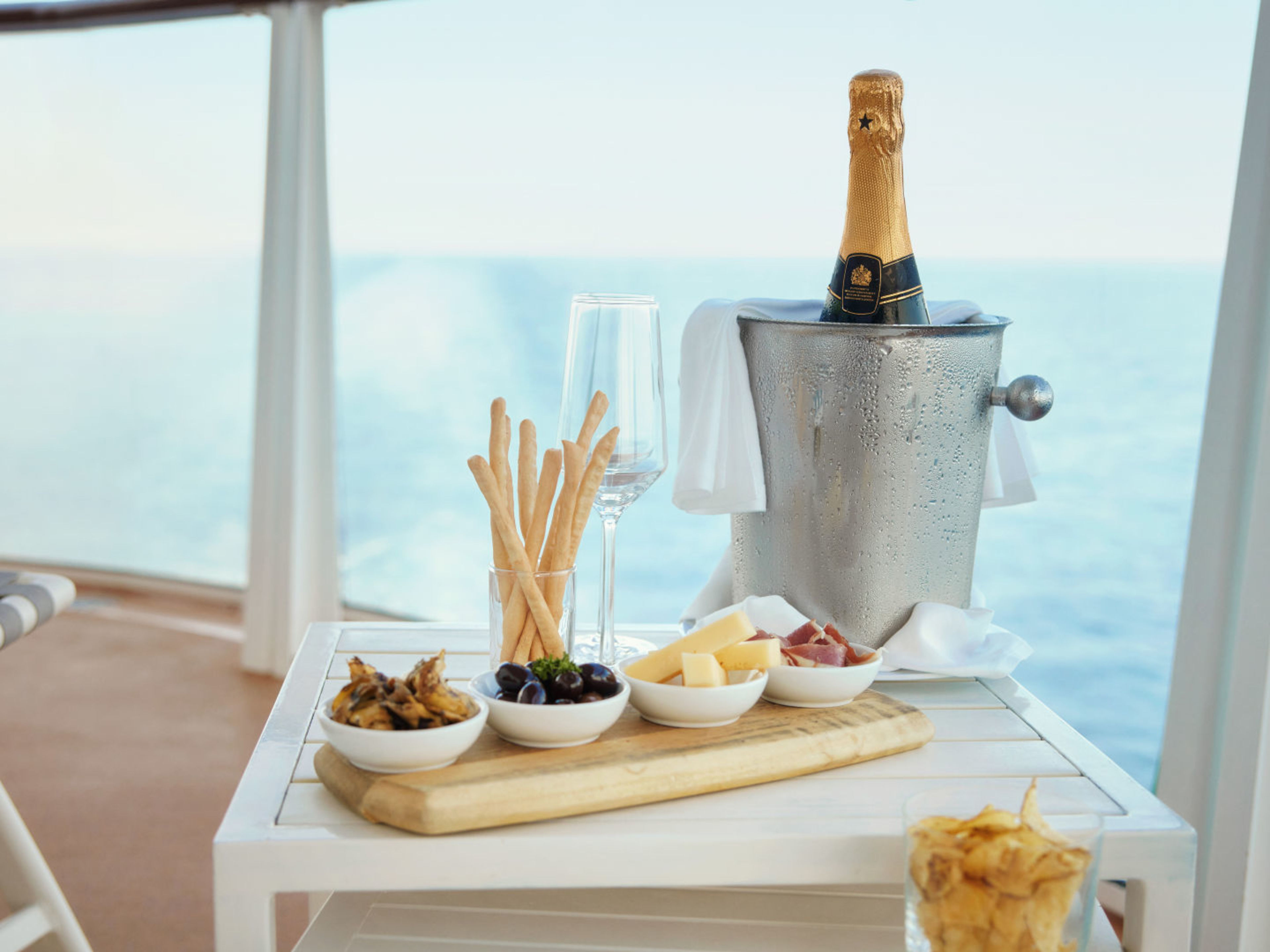 Sektflasche im Eiskübel, Snacks und Meerblick auf Kreuzfahrtschiff. Sektflasche im Eiskübel, Snacks und Meerblick auf Kreuzfahrtschiff.
