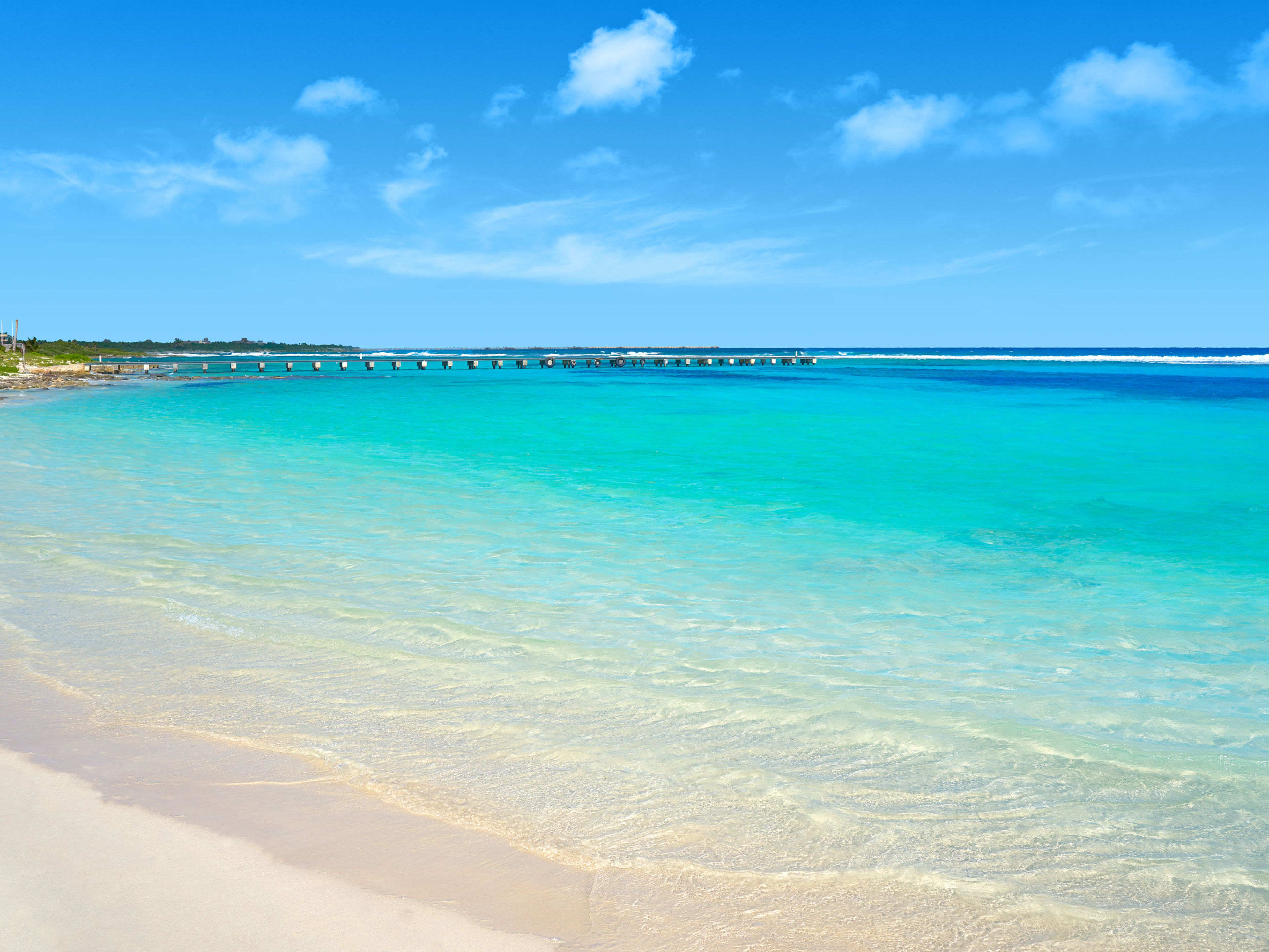 Strand mit türkisfarbenem Wasser, Leuchtturm und blauem Himmel. Strand mit türkisfarbenem Wasser, Leuchtturm und blauem Himmel.