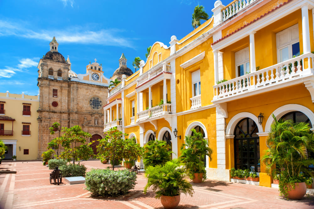 Gelbes Kolonialgebäude und Kirche in Cartagena, blauer Himmel. Gelbes Kolonialgebäude und Kirche in Cartagena, blauer Himmel.