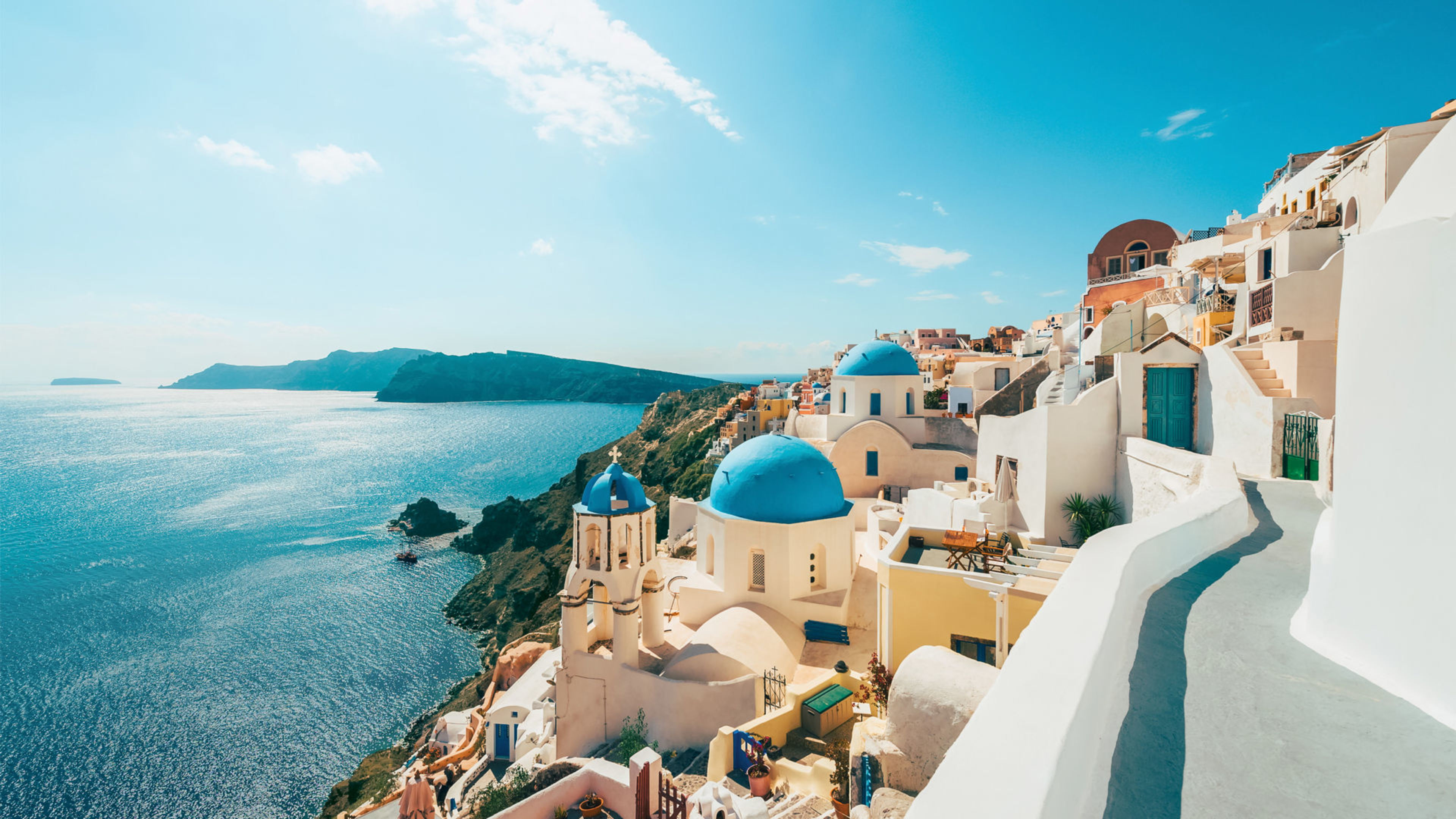 Santorini, weiße Gebäude, blaue Kuppeln, Meerblick, sonniger Himmel. Santorini, weiße Gebäude, blaue Kuppeln, Meerblick, sonniger Himmel.