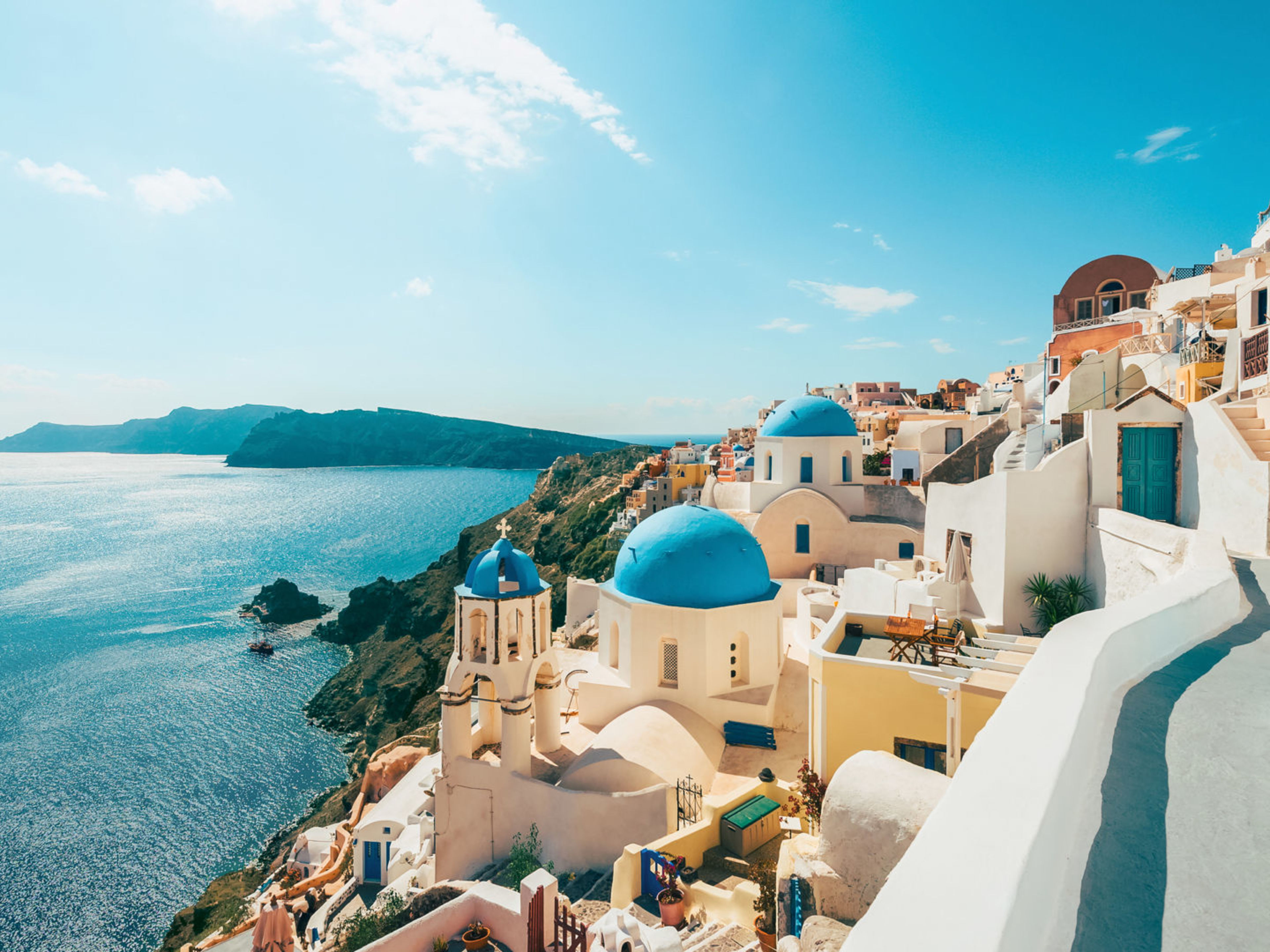 Santorini, weiße Gebäude, blaue Kuppeln, Meerblick, sonniger Himmel. Santorini, weiße Gebäude, blaue Kuppeln, Meerblick, sonniger Himmel.