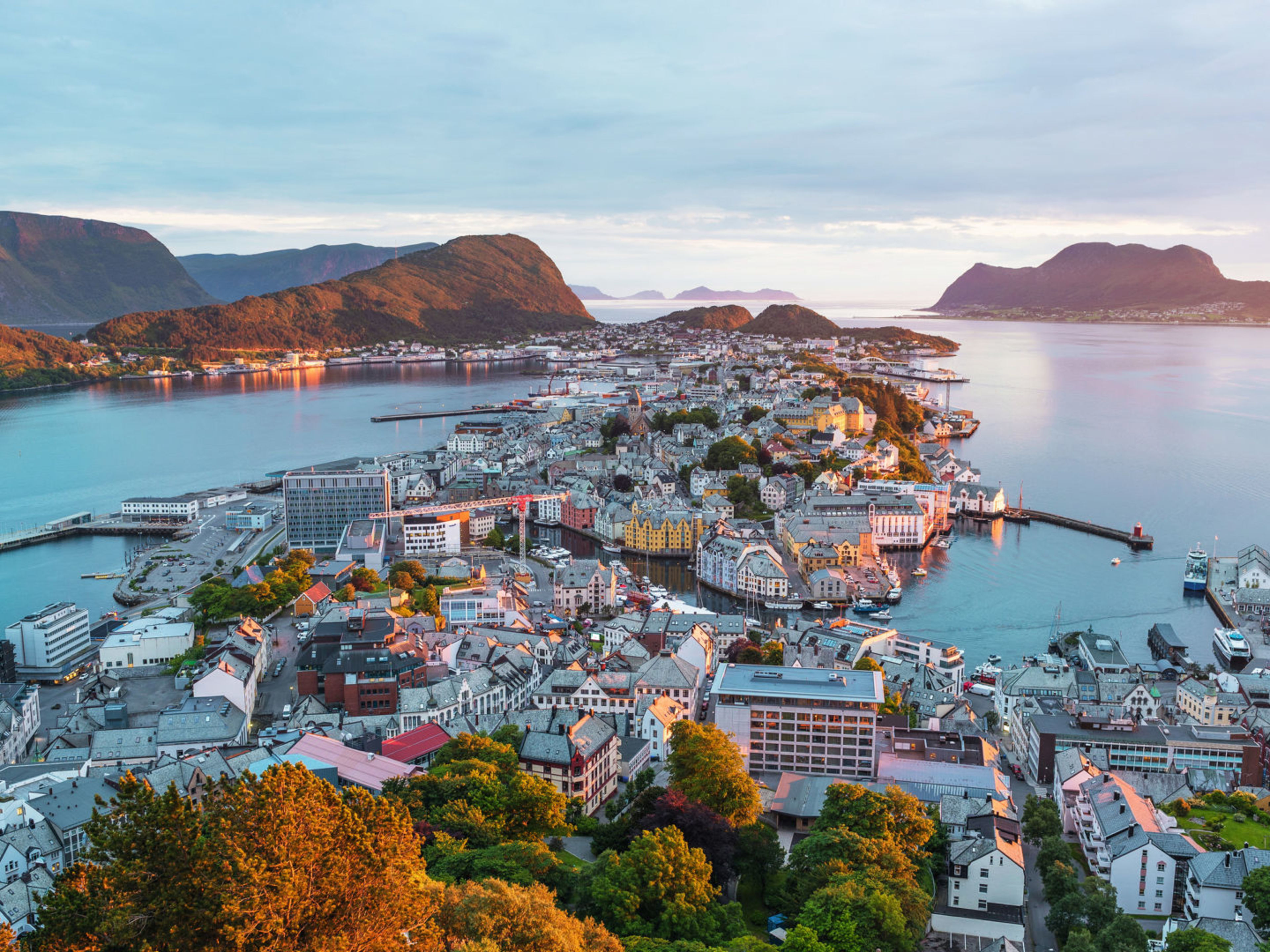 Blick auf Ålesund, Norwegen, bei Sonnenuntergang mit Fjorden und bunten Häusern. Blick auf Ålesund, Norwegen, bei Sonnenuntergang mit Fjorden und bunten Häusern.