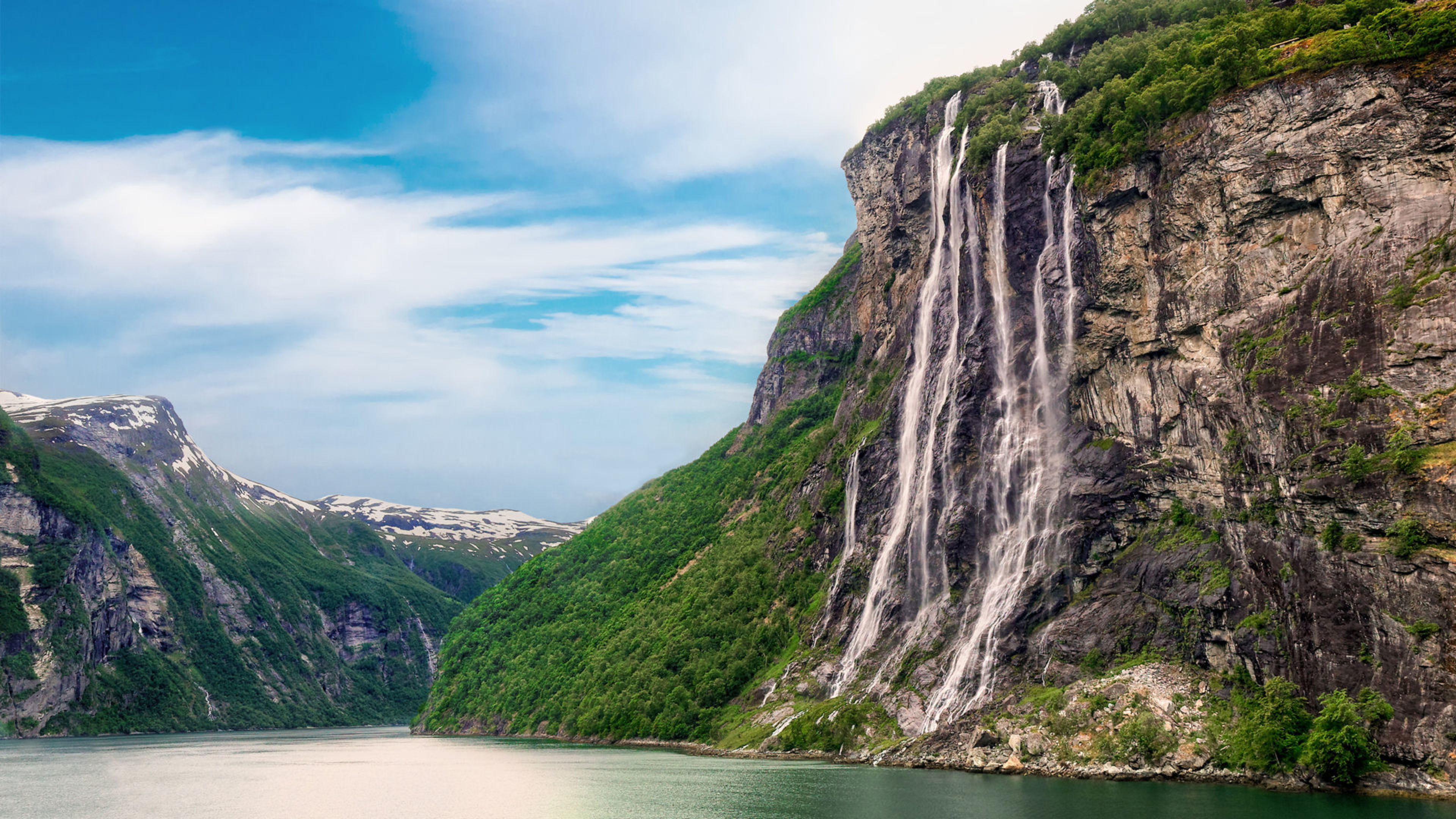 Wasserfall im Geirangerfjord, Norwegen, mit grünen Bergen und blauem Himmel. Wasserfall im Geirangerfjord, Norwegen, mit grünen Bergen und blauem Himmel.