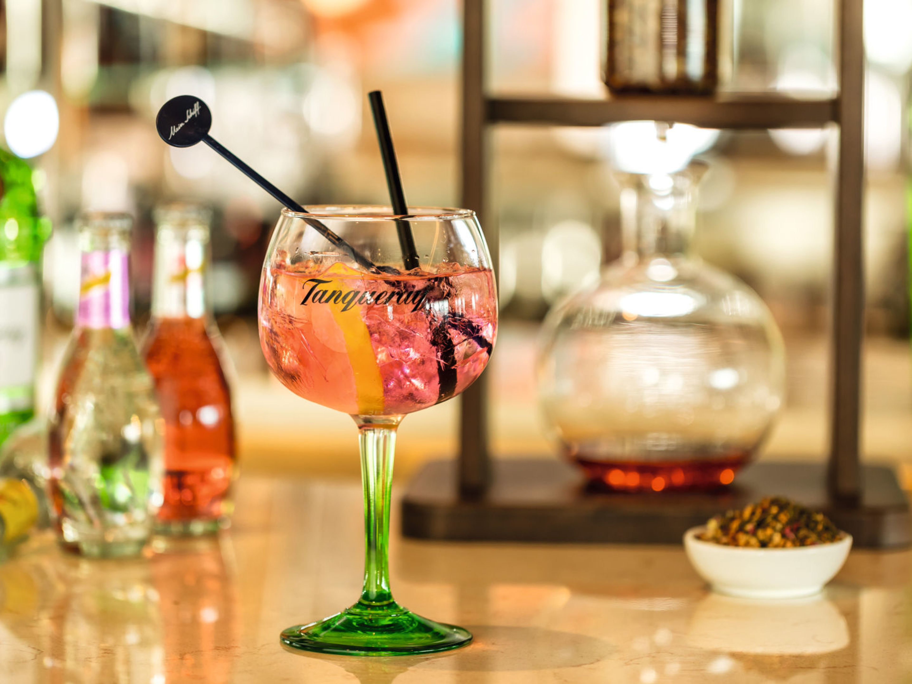 Cocktailglas mit rosa Getränk, Zitronenscheibe, Barhintergrund. Cocktailglas mit rosa Getränk, Zitronenscheibe, Barhintergrund.