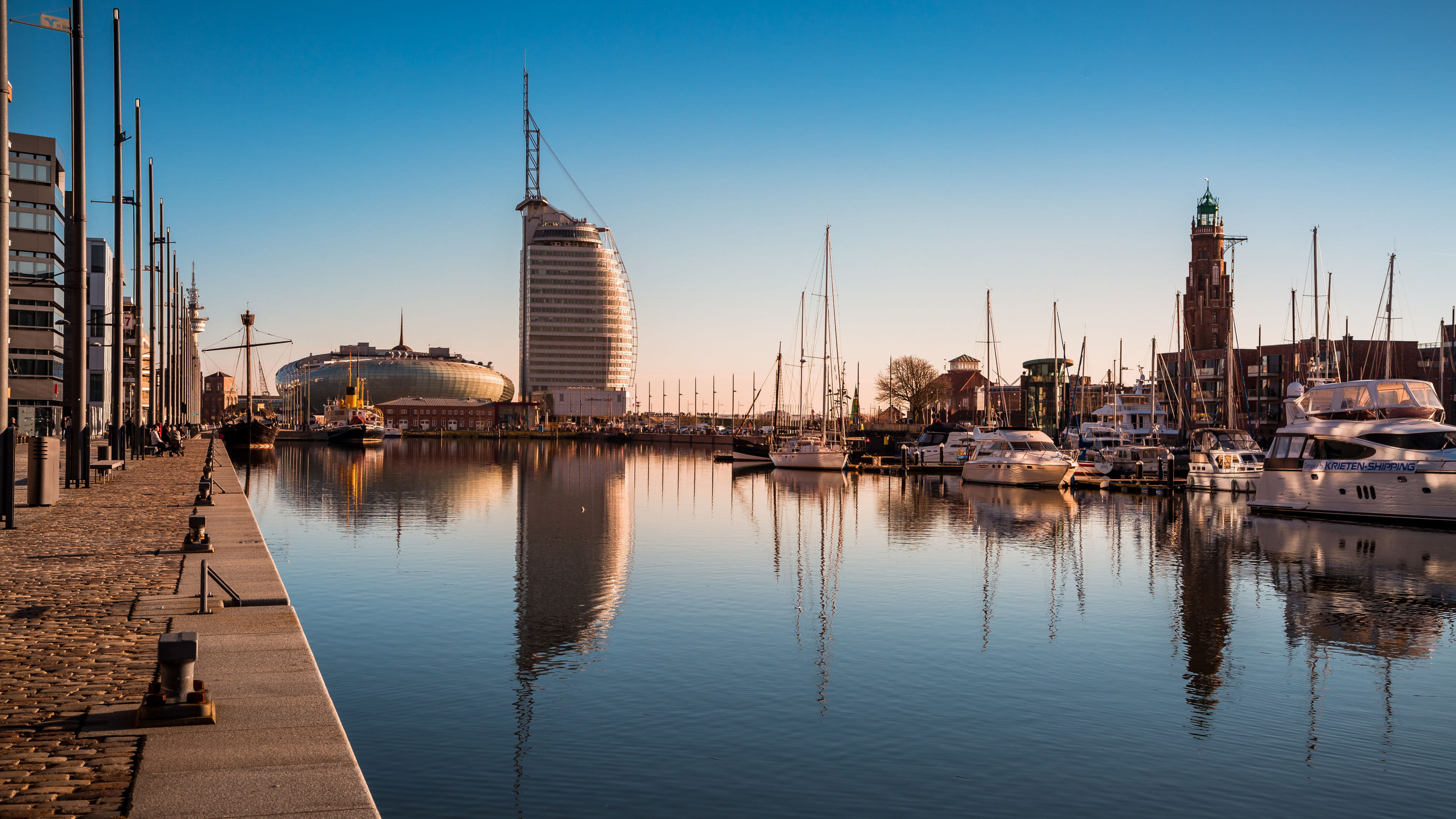 Bremerhaven Hafen mit Segelbooten, modernem Gebäude und klarem Himmel. Bremerhaven Hafen mit Segelbooten, modernem Gebäude und klarem Himmel.