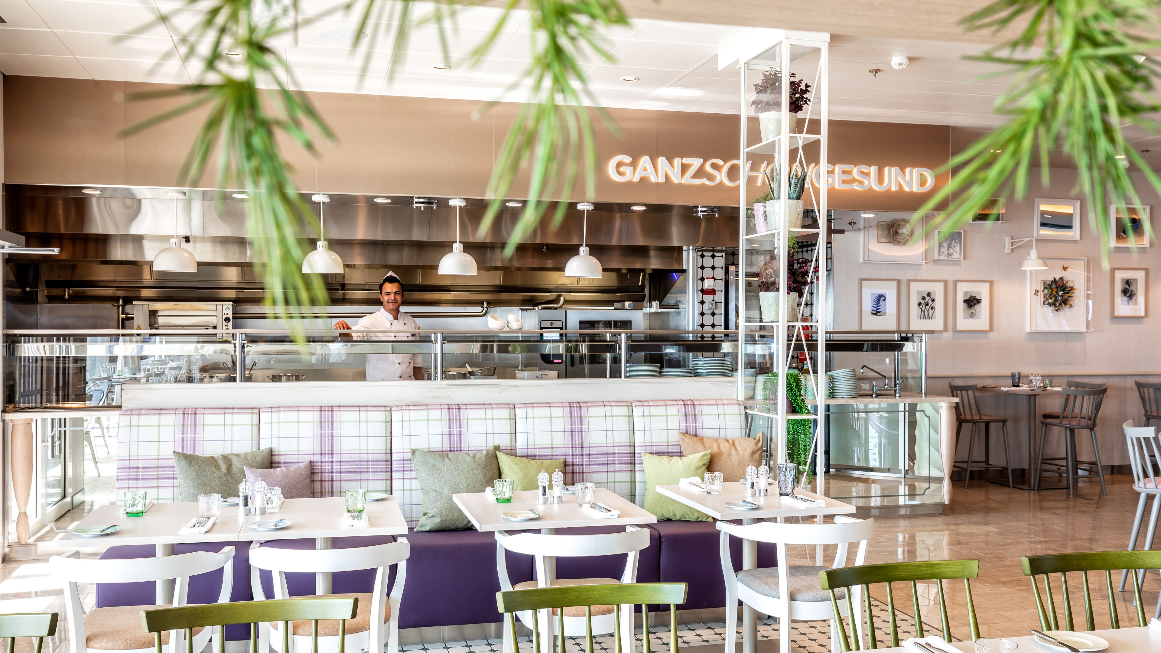 Restaurant mit Koch, modernen Möbeln und Pflanzen, helle Atmosphäre. Restaurant mit Koch, modernen Möbeln und Pflanzen, helle Atmosphäre.