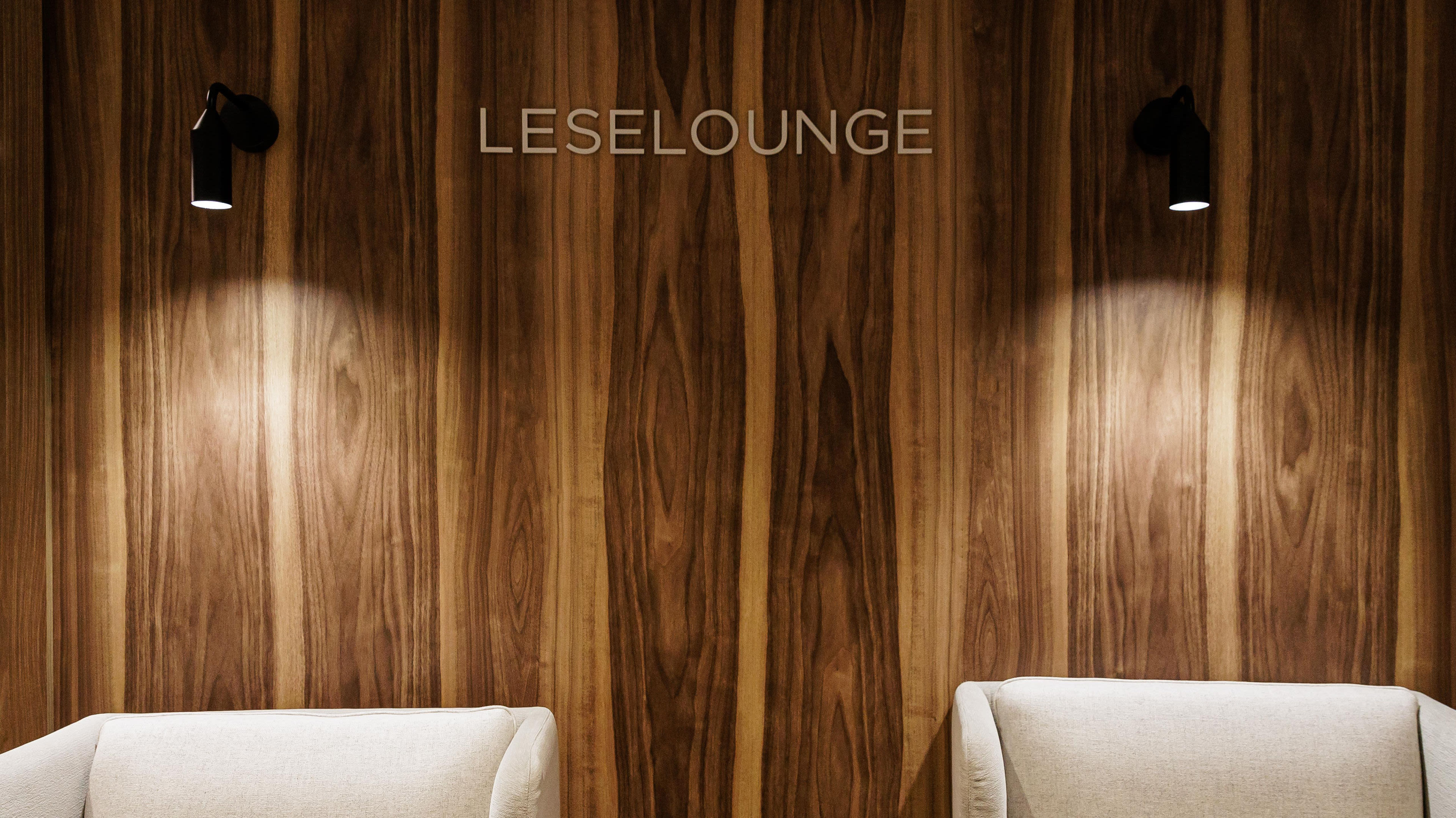 Zwei Sessel vor Holzwand mit Schriftzug "Leselounge".