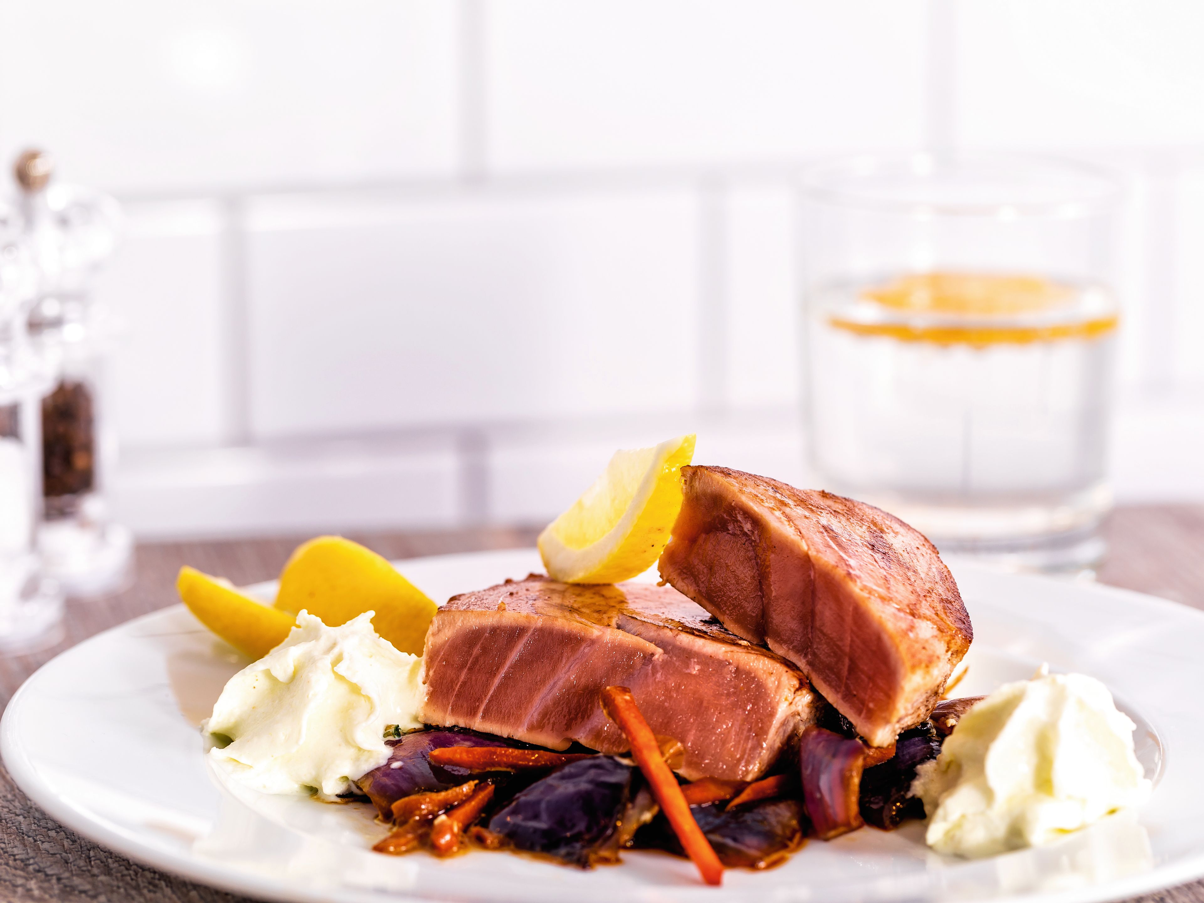 Gegrillter Thunfisch mit Zitronenscheiben, Gemüse und Kartoffelpüree auf weißem Teller. Gegrillter Thunfisch mit Zitronenscheiben, Gemüse und Kartoffelpüree auf weißem Teller.
