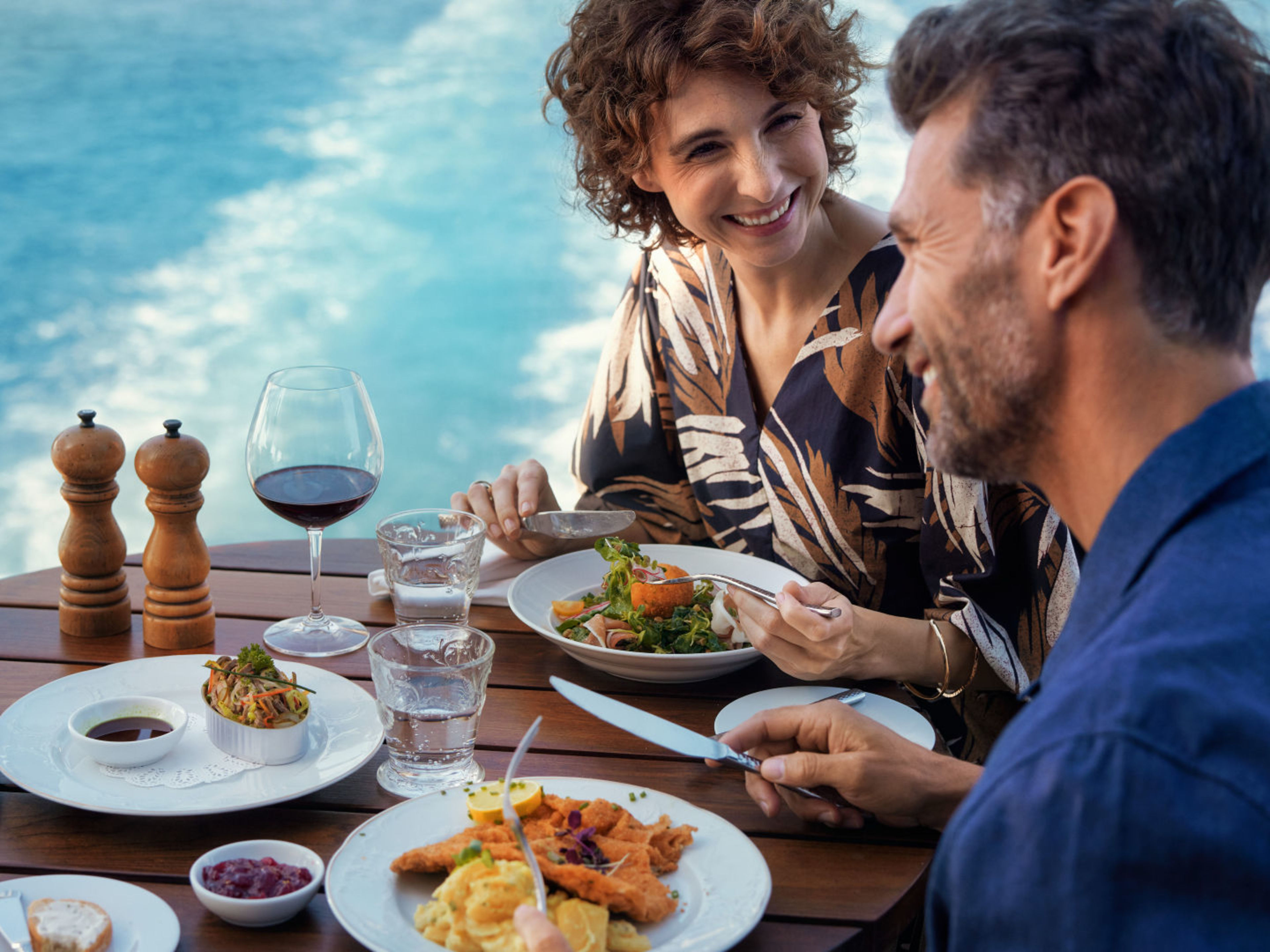 Paar genießt Mittagessen auf Kreuzfahrtschiff, Meerblick, Wein. Paar genießt Mittagessen auf Kreuzfahrtschiff, Meerblick, Wein.