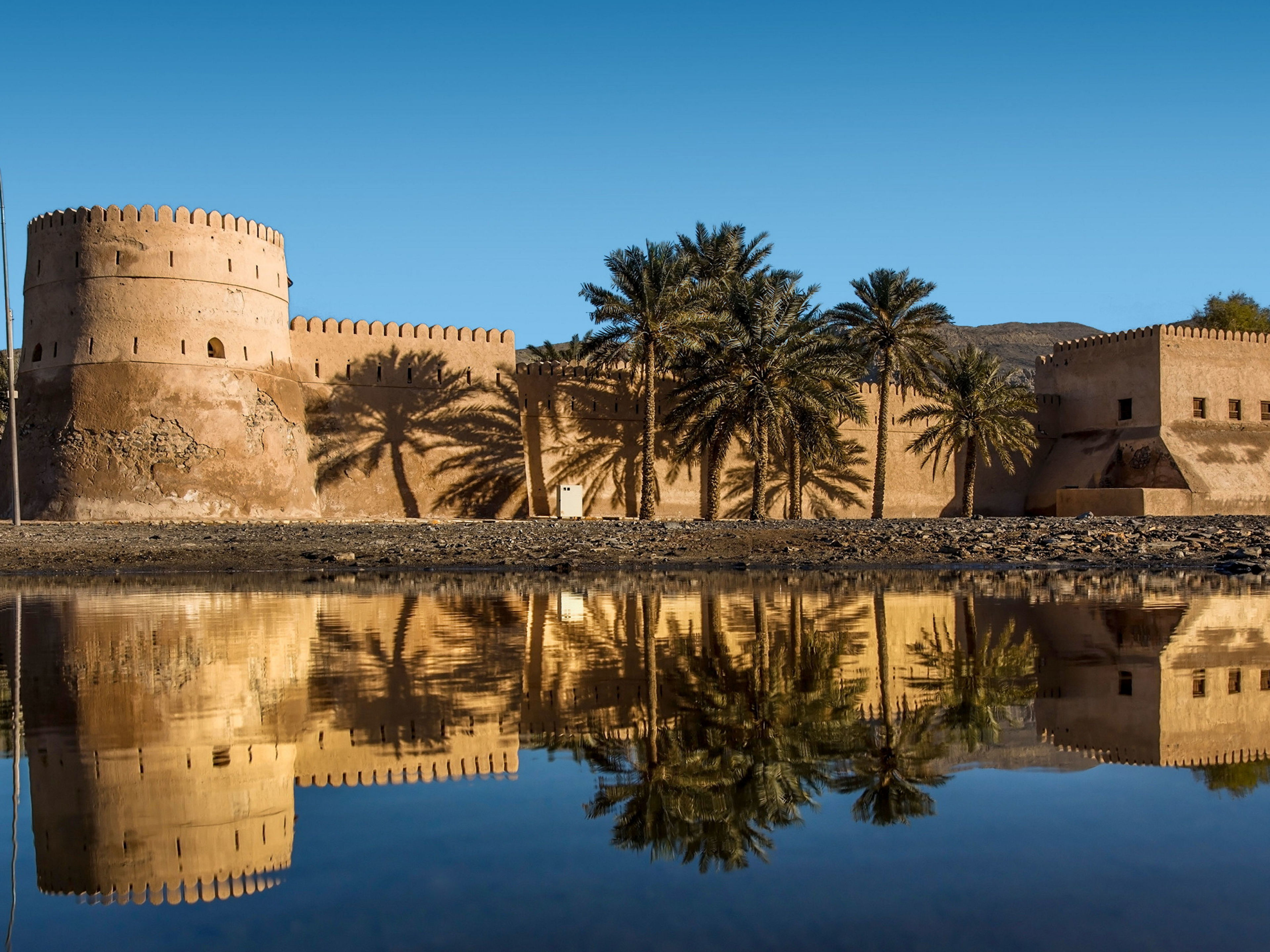 Altes Fort mit Palmen und Spiegelung im Wasser, blauer Himmel. Altes Fort mit Palmen und Spiegelung im Wasser, blauer Himmel.