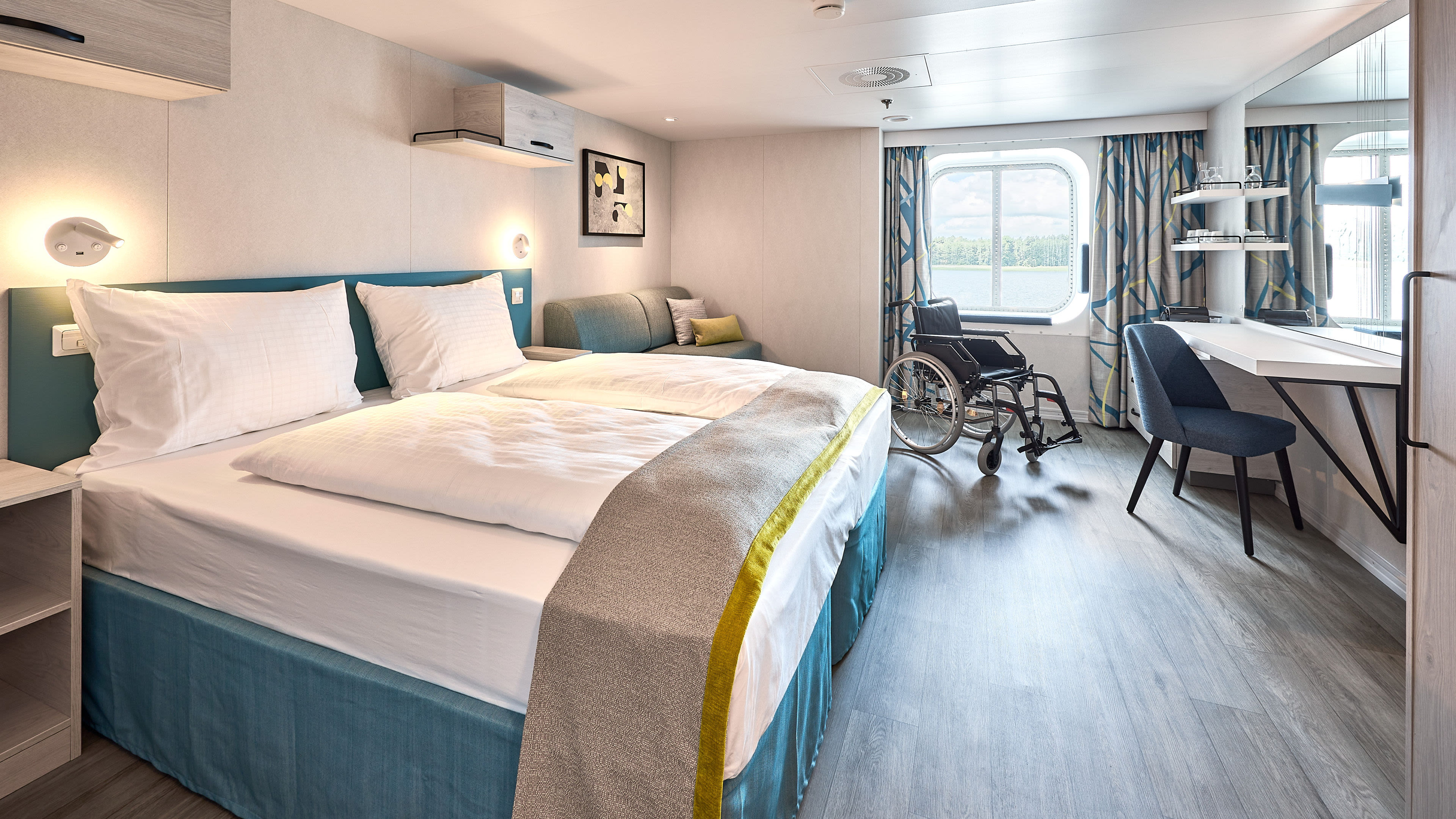 Barrierefreies Kreuzfahrtschiffzimmer mit Doppelbett, Rollstuhl, Schreibtisch und Fensterblick. Barrierefreies Kreuzfahrtschiffzimmer mit Doppelbett, Rollstuhl, Schreibtisch und Fensterblick.
