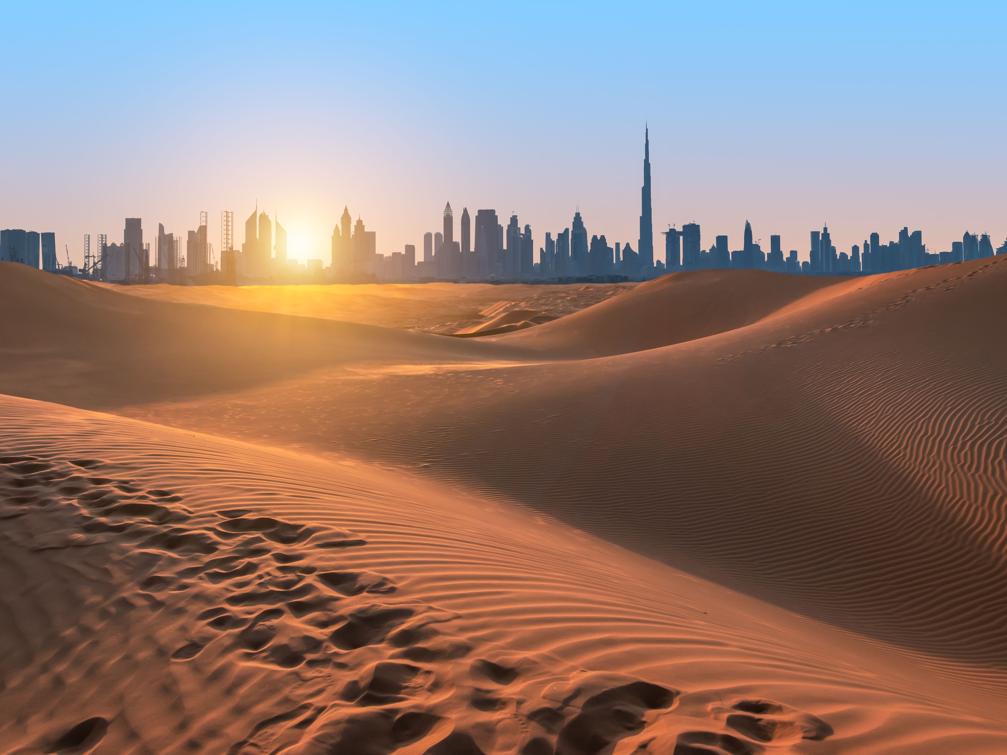 Wüstenlandschaft bei Sonnenuntergang, Dubai Skyline im Hintergrund. Wüstenlandschaft bei Sonnenuntergang, Dubai Skyline im Hintergrund.