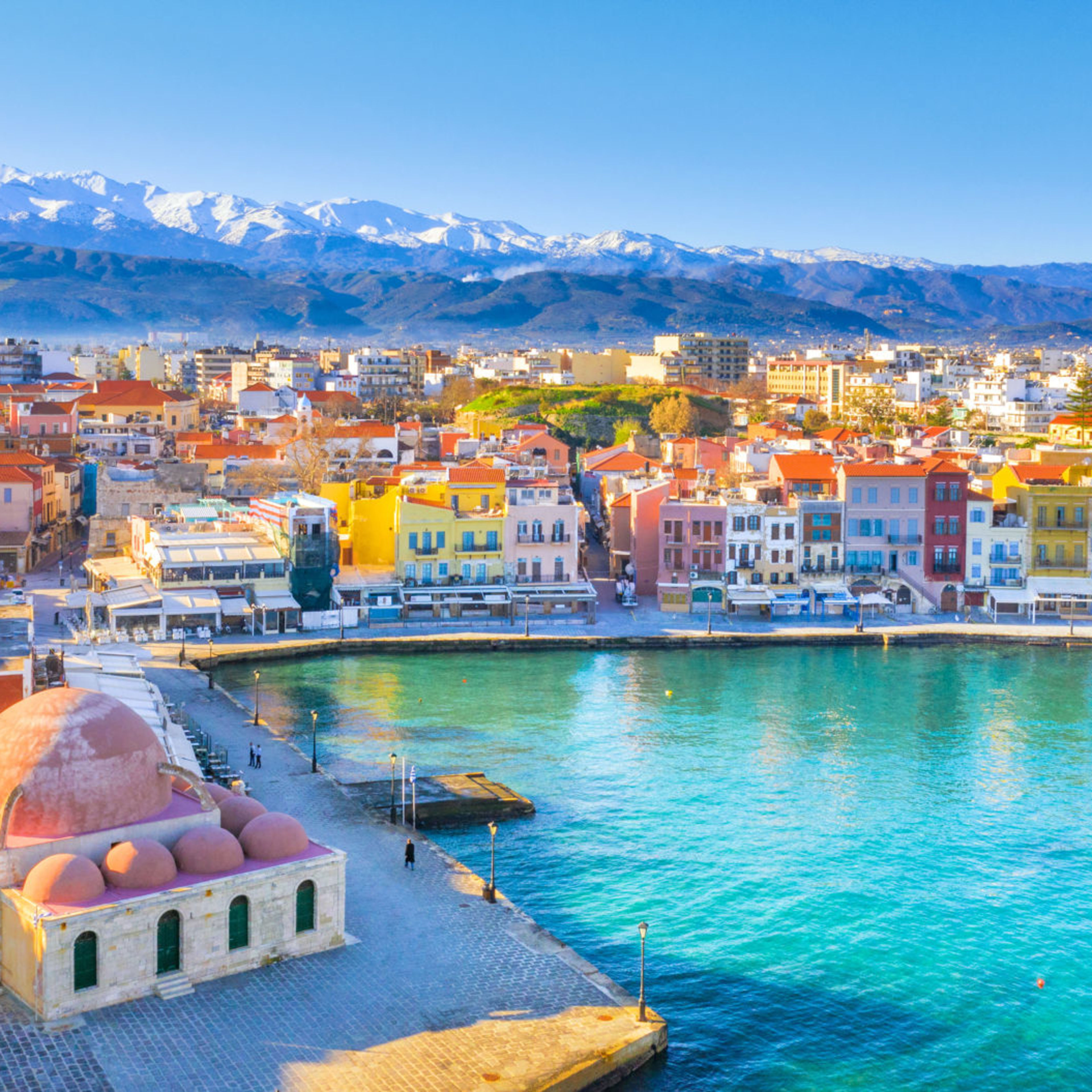 Bunte Häuser am Hafen von Chania, Kreta, mit schneebedeckten Bergen im Hintergrund. Bunte Häuser am Hafen von Chania, Kreta, mit schneebedeckten Bergen im Hintergrund.
