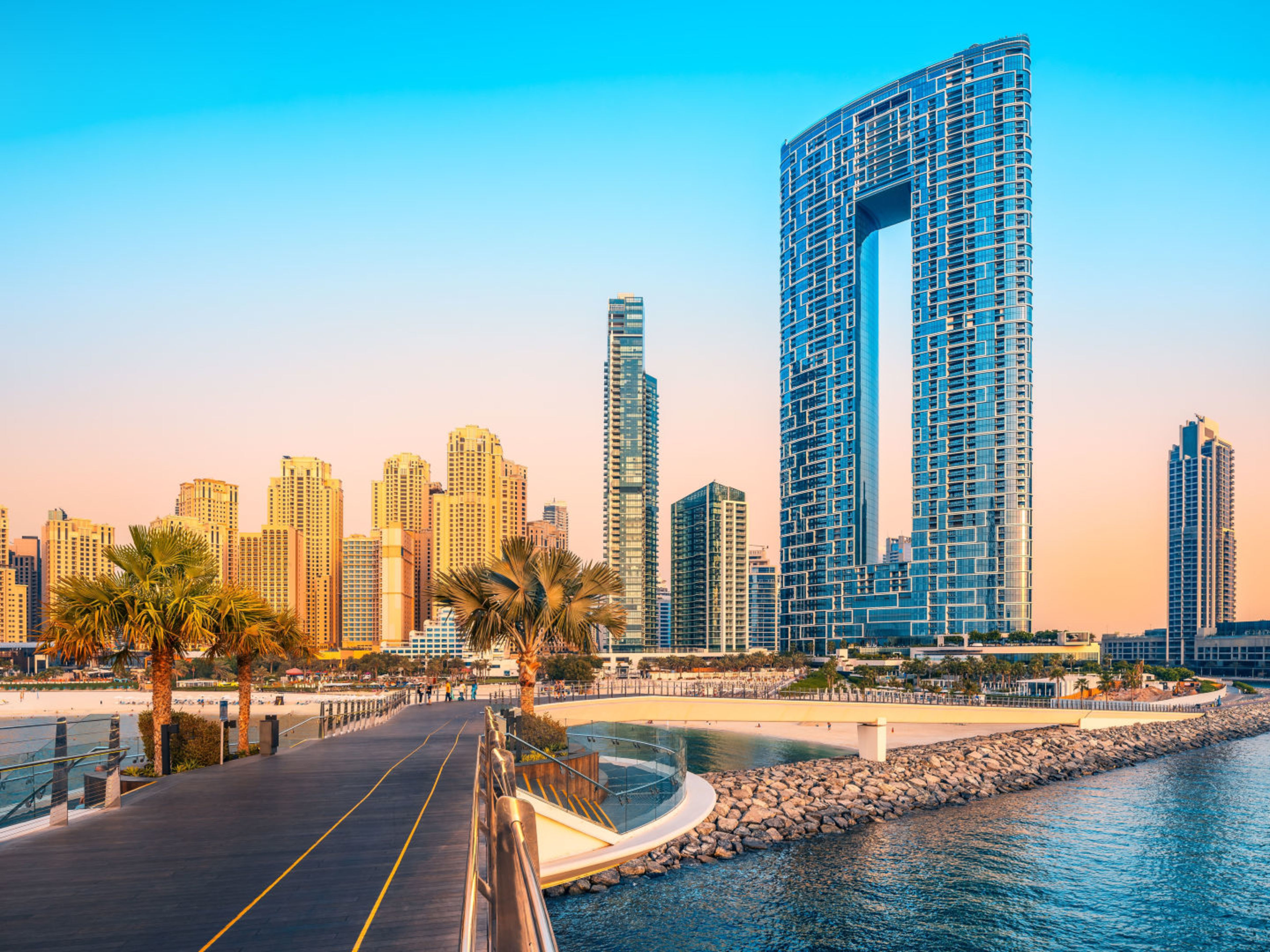 Dubai Marina bei Sonnenuntergang, moderne Wolkenkratzer, Palmen, Promenade. Dubai Marina bei Sonnenuntergang, moderne Wolkenkratzer, Palmen, Promenade.