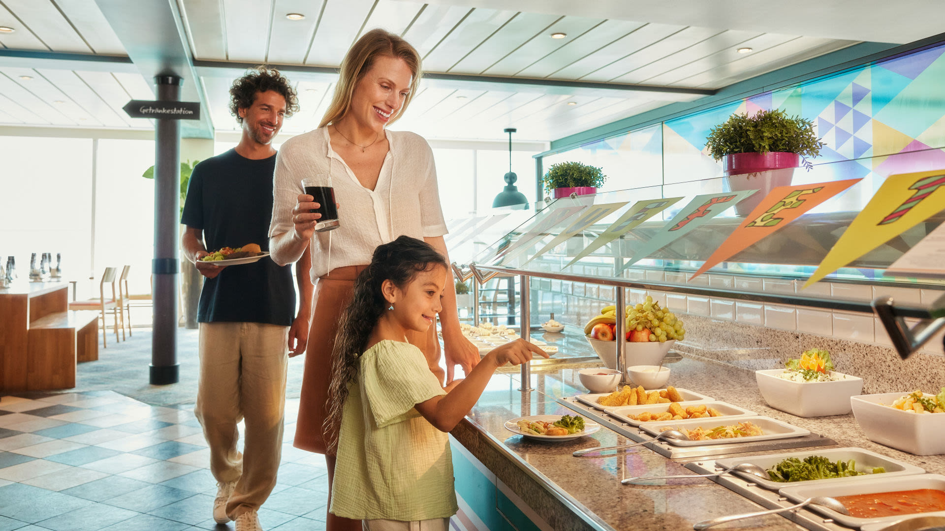 Familie am Buffet auf Kreuzfahrtschiff der Mein Schiff® Flotte, fröhlich essend.