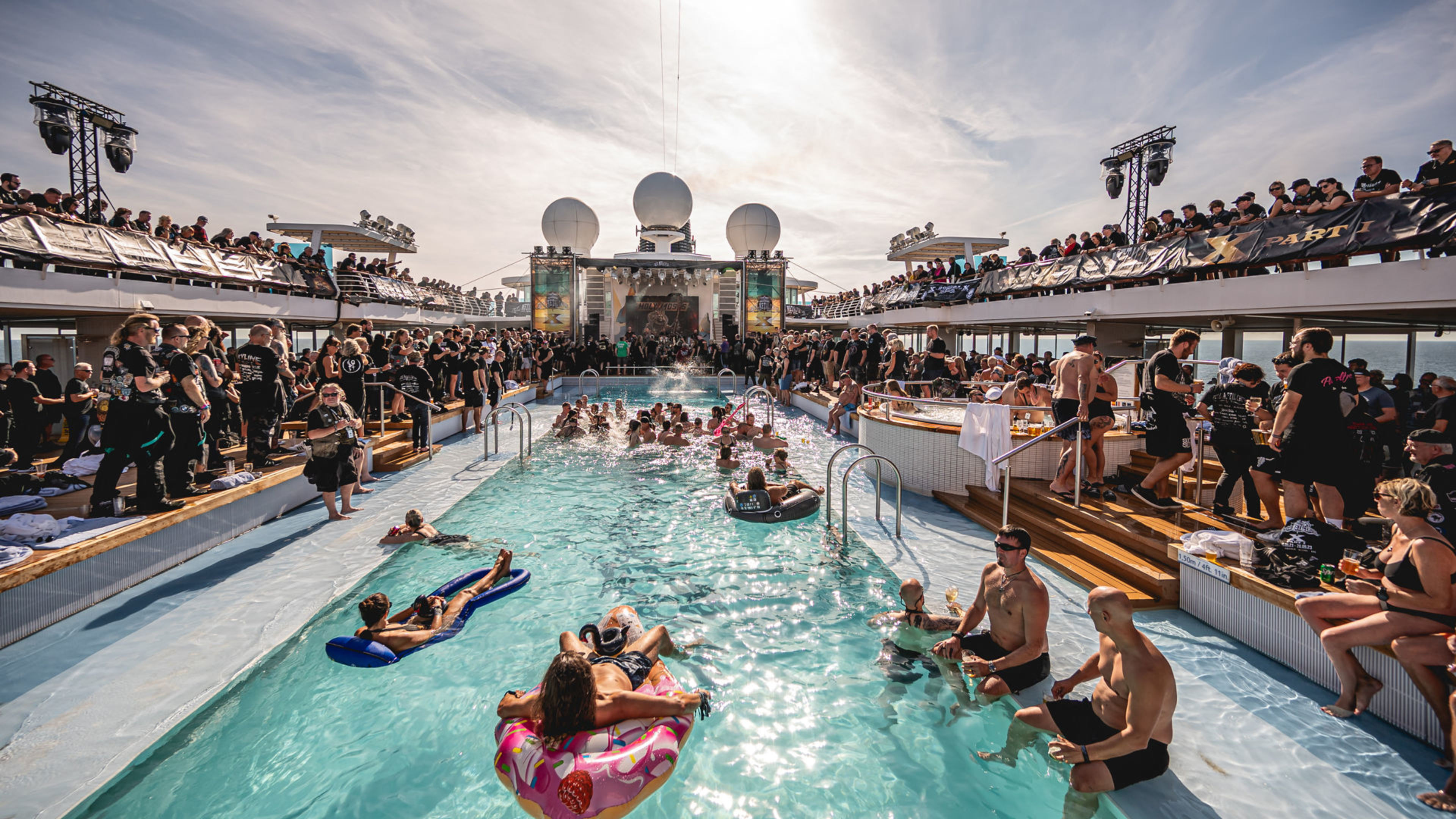 Menschen feiern am Pool auf einem Kreuzfahrtschiff der Mein Schiff® Flotte. Menschen feiern am Pool auf einem Kreuzfahrtschiff der Mein Schiff® Flotte.