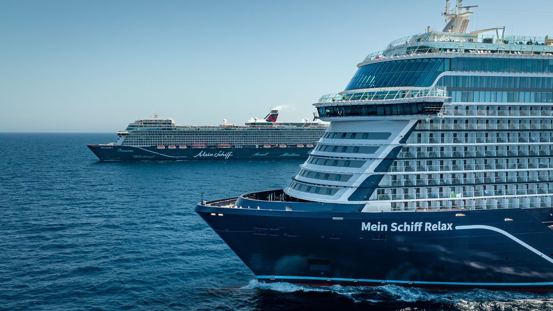 Zwei Kreuzfahrtschiffe der Mein Schiff® Flotte auf offenem Meer.