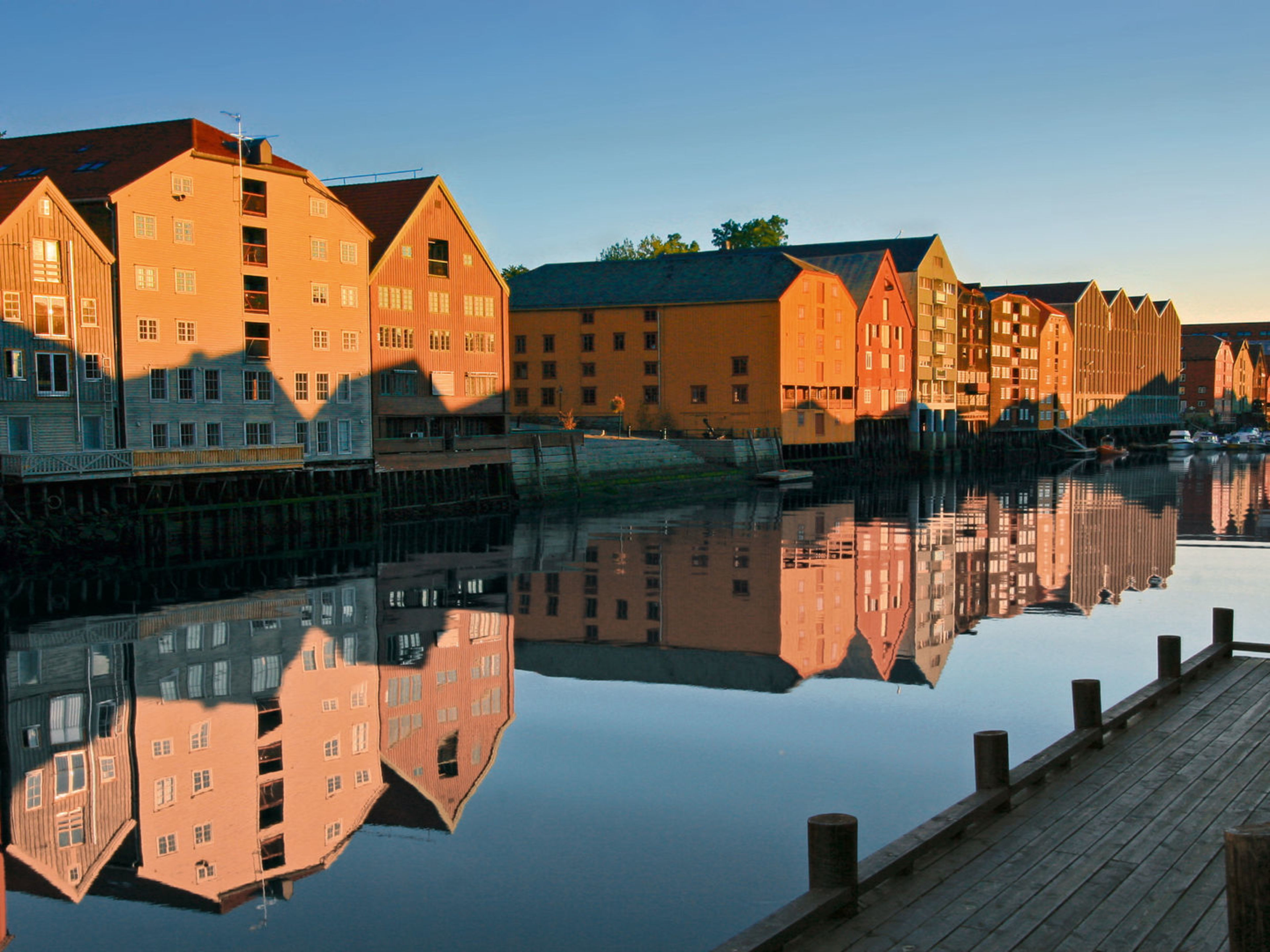 Bunte Lagerhäuser spiegeln sich im Fluss in Trondheim. Bunte Lagerhäuser spiegeln sich im Fluss in Trondheim.