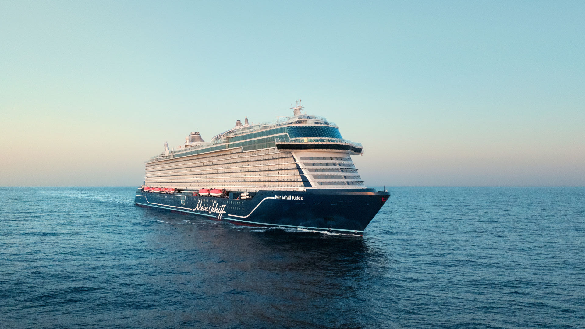 Kreuzfahrtschiff der Mein Schiff® Flotte auf offenem Meer bei Sonnenuntergang. Kreuzfahrtschiff der Mein Schiff® Flotte auf offenem Meer bei Sonnenuntergang.