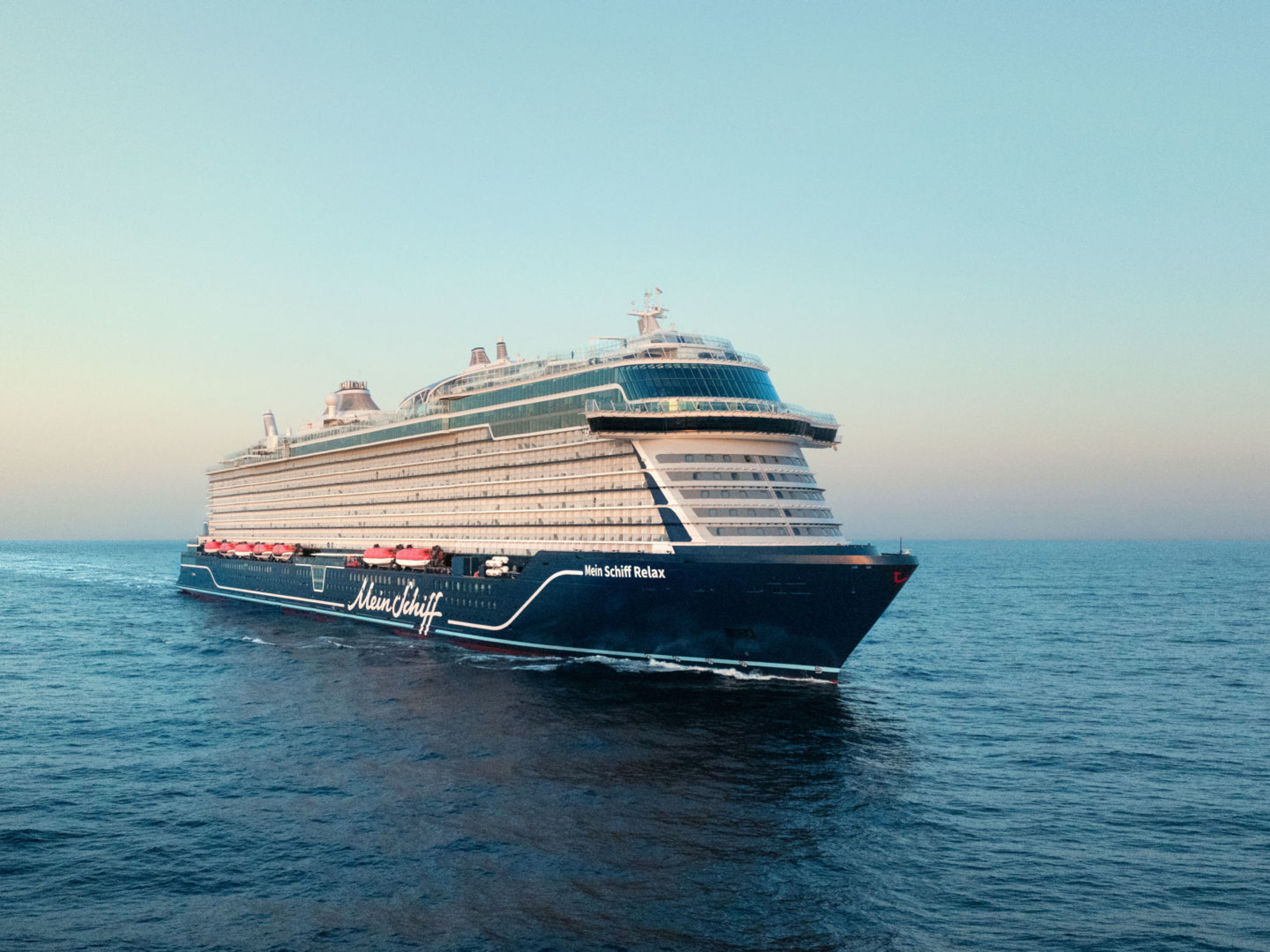 Kreuzfahrtschiff der Mein Schiff® Flotte auf offenem Meer bei Sonnenuntergang. Kreuzfahrtschiff der Mein Schiff® Flotte auf offenem Meer bei Sonnenuntergang.