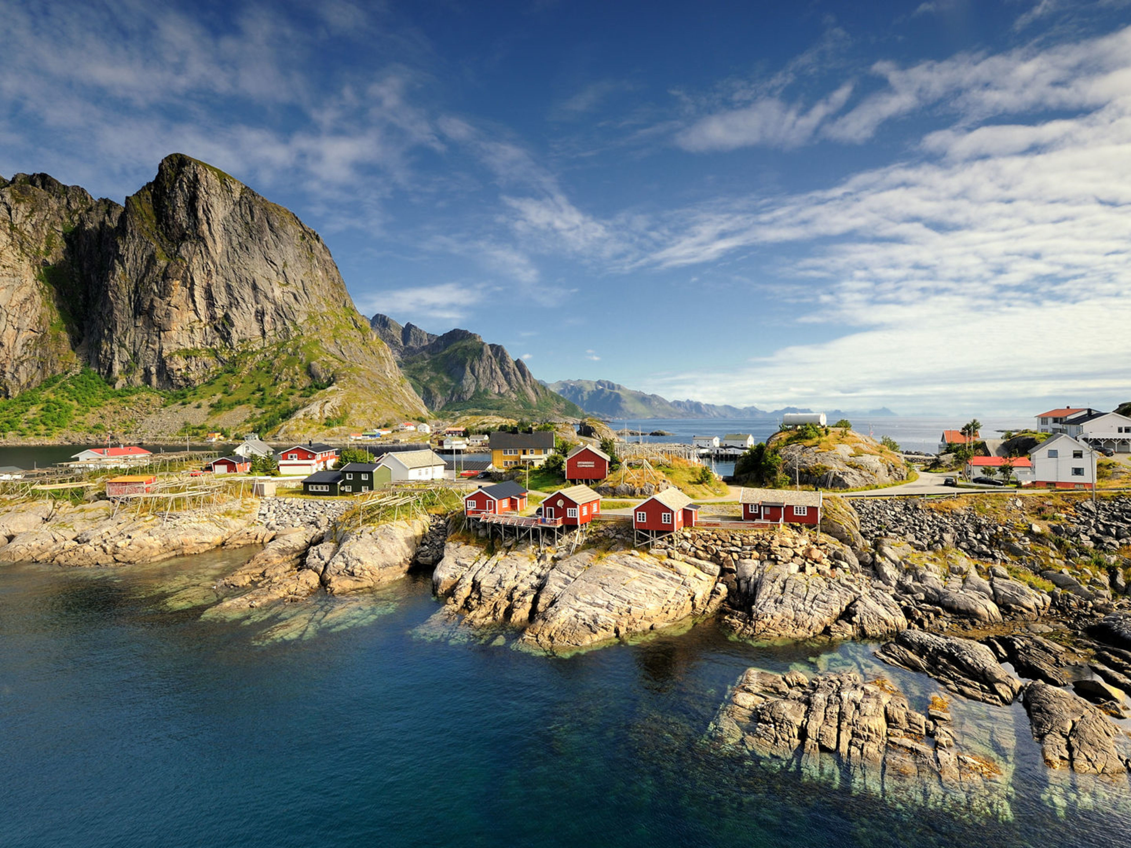 Bunte Häuser auf Lofoten-Inseln vor majestätischen Bergen und blauem Himmel. Bunte Häuser auf Lofoten-Inseln vor majestätischen Bergen und blauem Himmel.