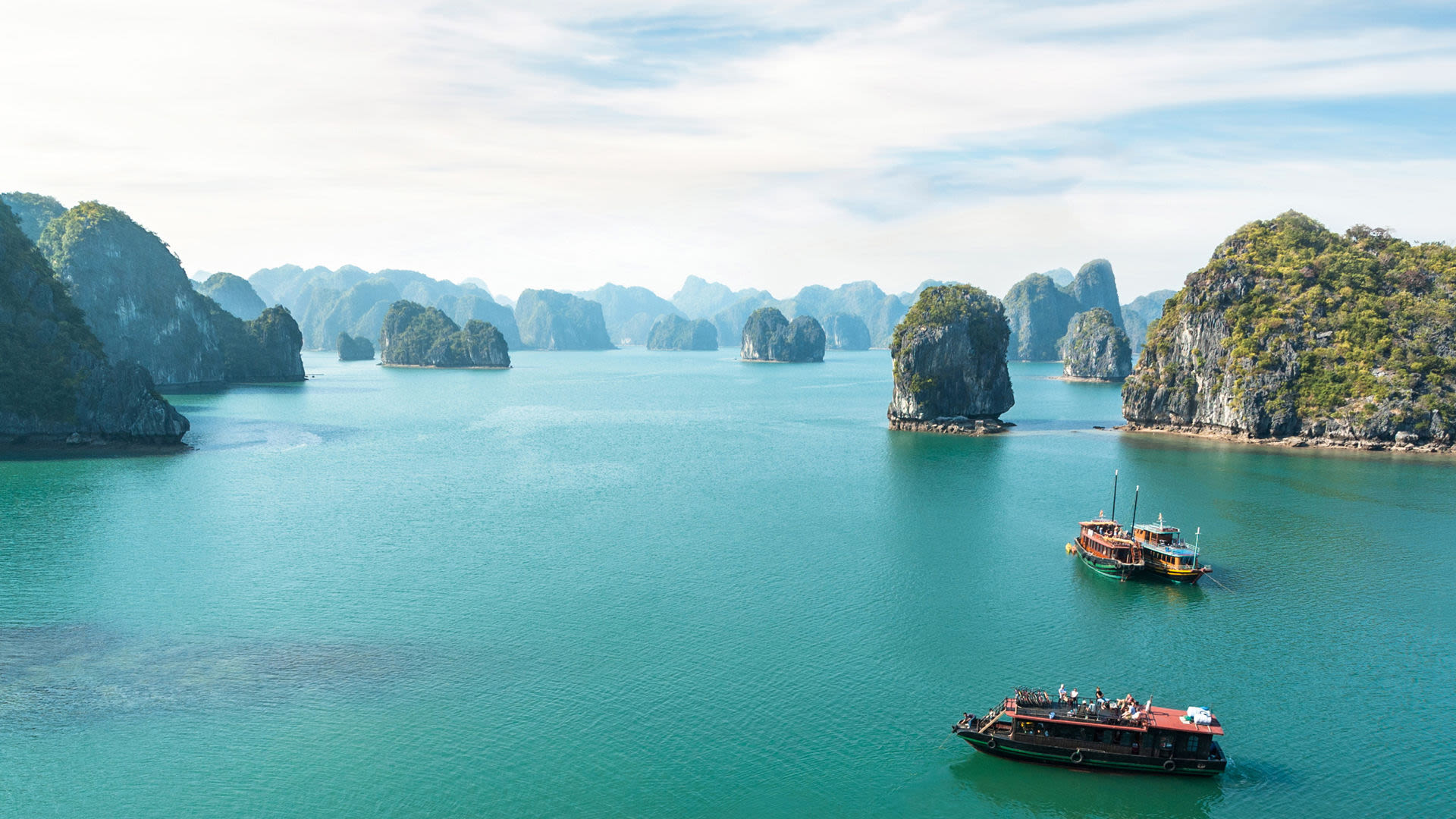 Boote auf türkisfarbenem Wasser in der Halong-Bucht, Vietnam.