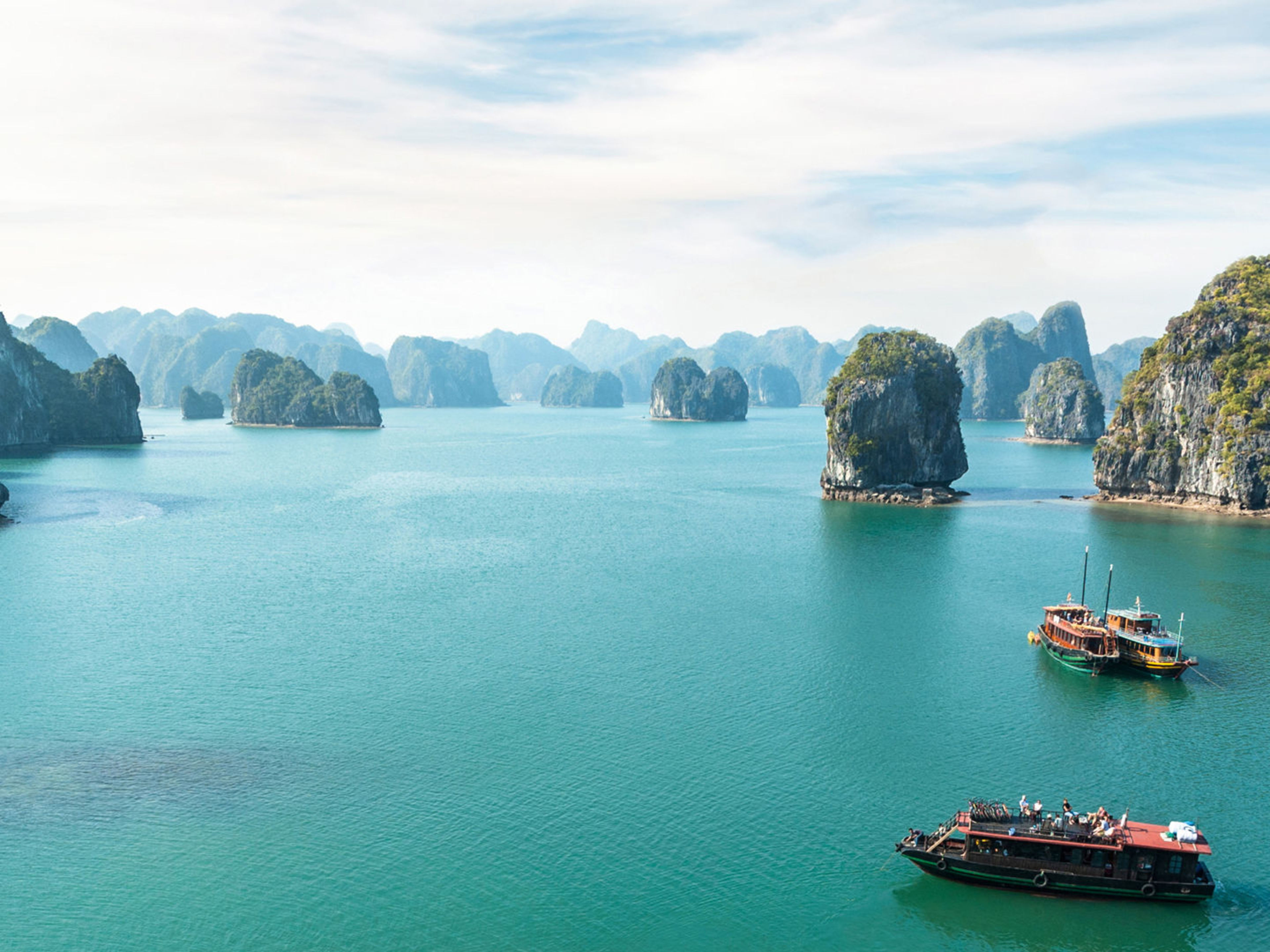 Boote auf türkisfarbenem Wasser in der Halong-Bucht, Vietnam. Boote auf türkisfarbenem Wasser in der Halong-Bucht, Vietnam.