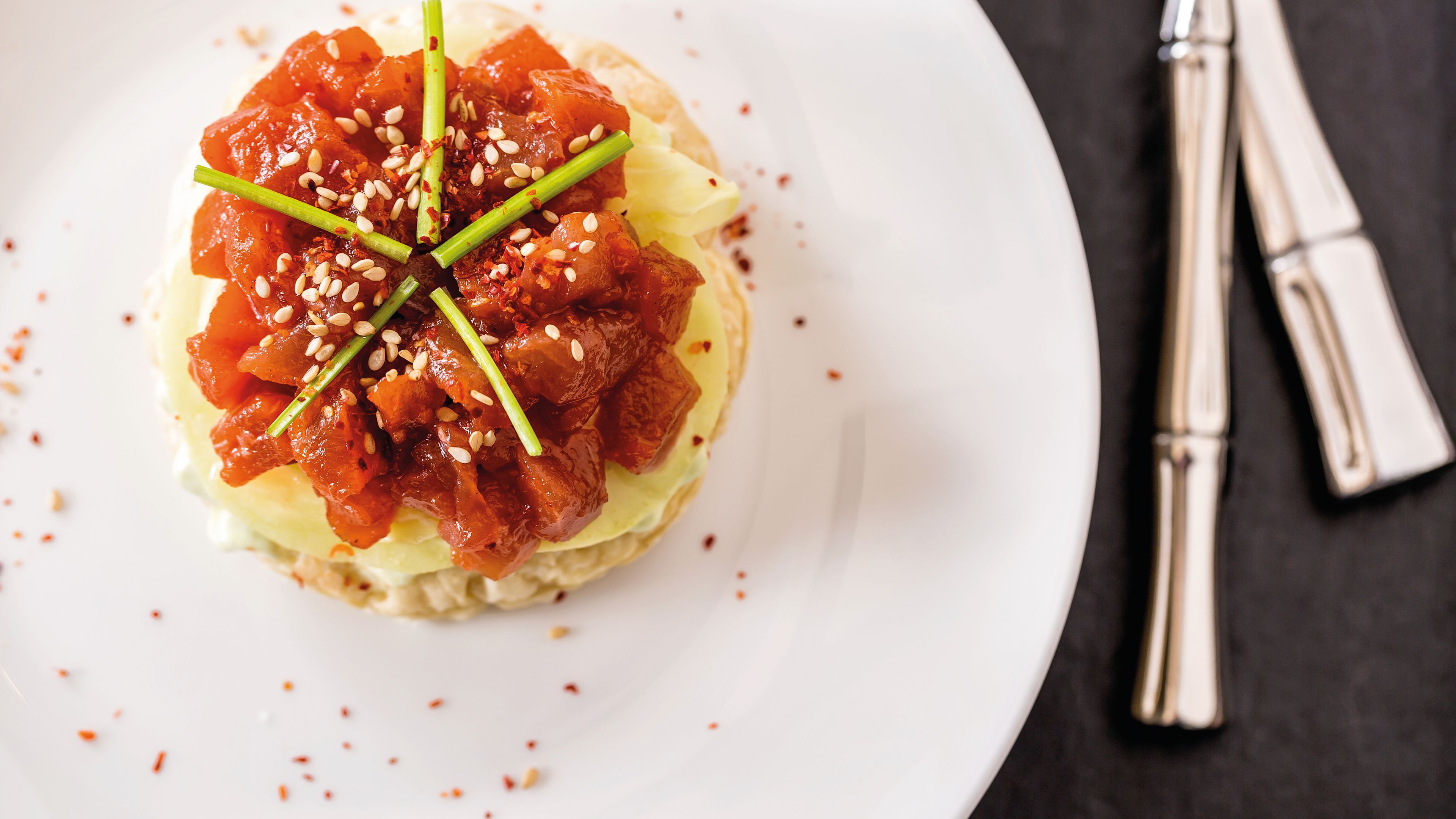 Gourmet starter: Japanese pizza with salmon, sesame seeds and chives, served on a white plate. Gourmet starter: Japanese pizza with salmon, sesame seeds and chives, served on a white plate.